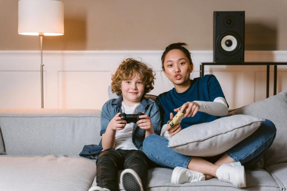A therapist bonding a child she supports, playing a video game side-by-side.