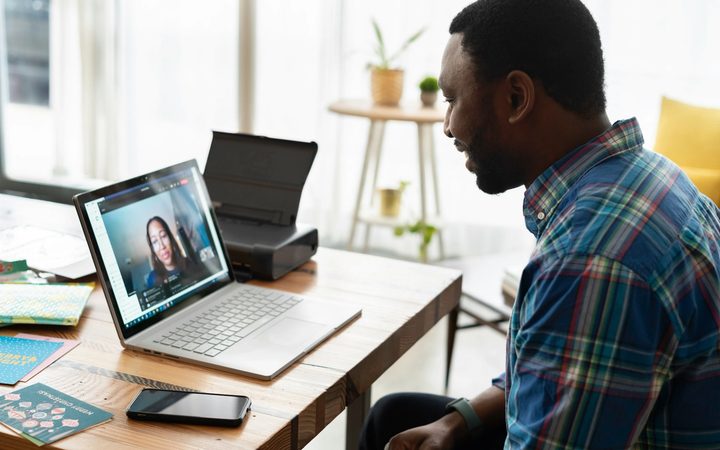 Man in blue and white plaid dress shirt using macbook pro