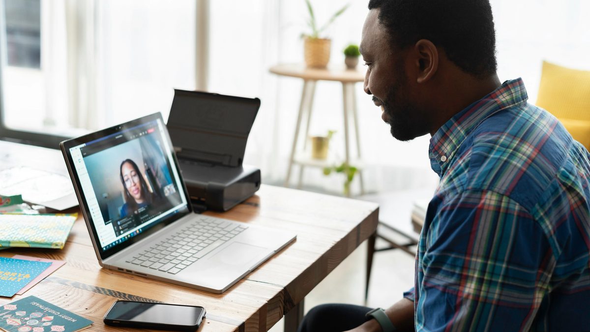 Man in blue and white plaid dress shirt using macbook pro