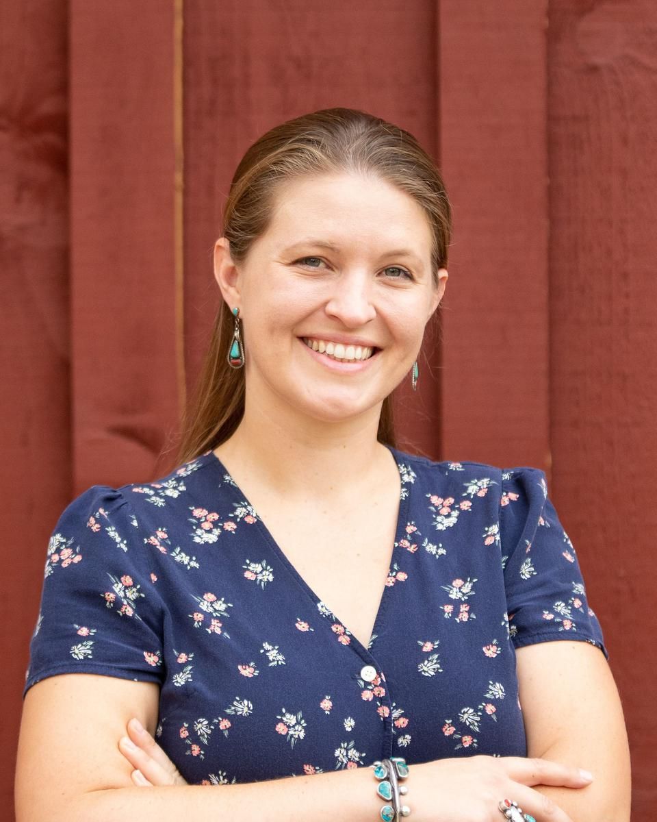 Alma therapist Pilar Coppers, standing outside a red building and smiling to the camera.