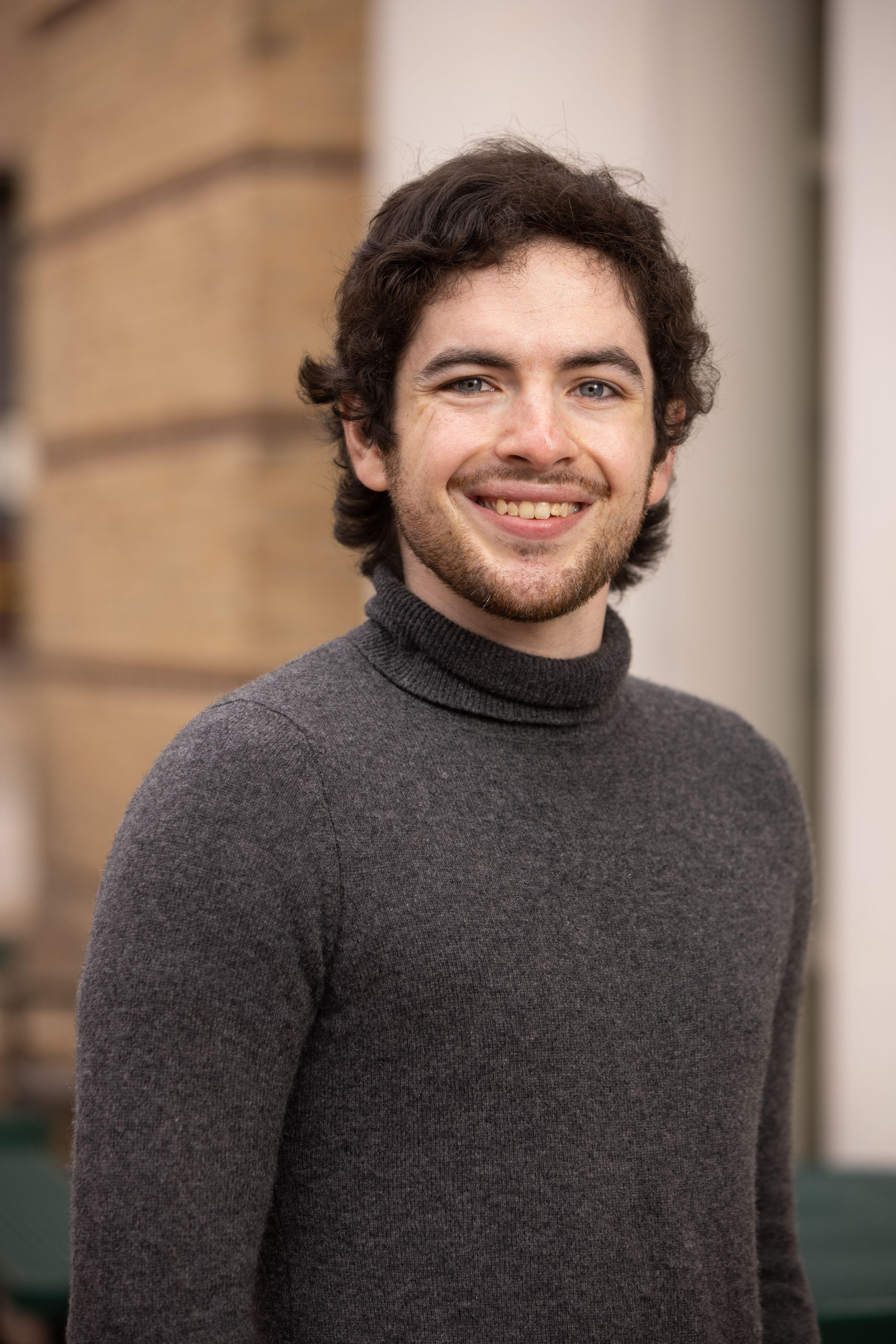 Michael O'Brien, a final-year doctoral candidate, standing in his collegiate graduation garb.
