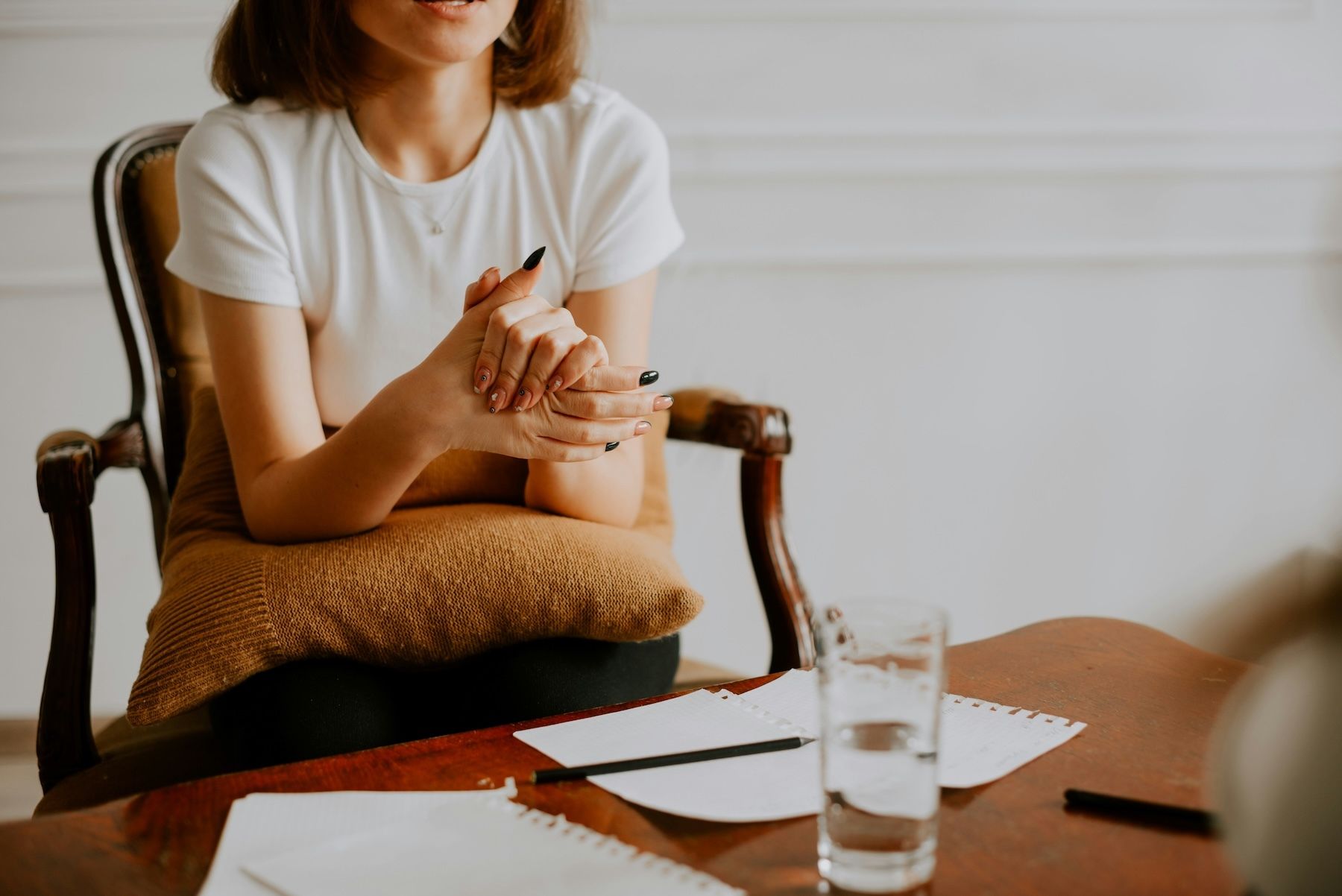 Man sitting on an orange couch speaking with a therapist who is taking notes