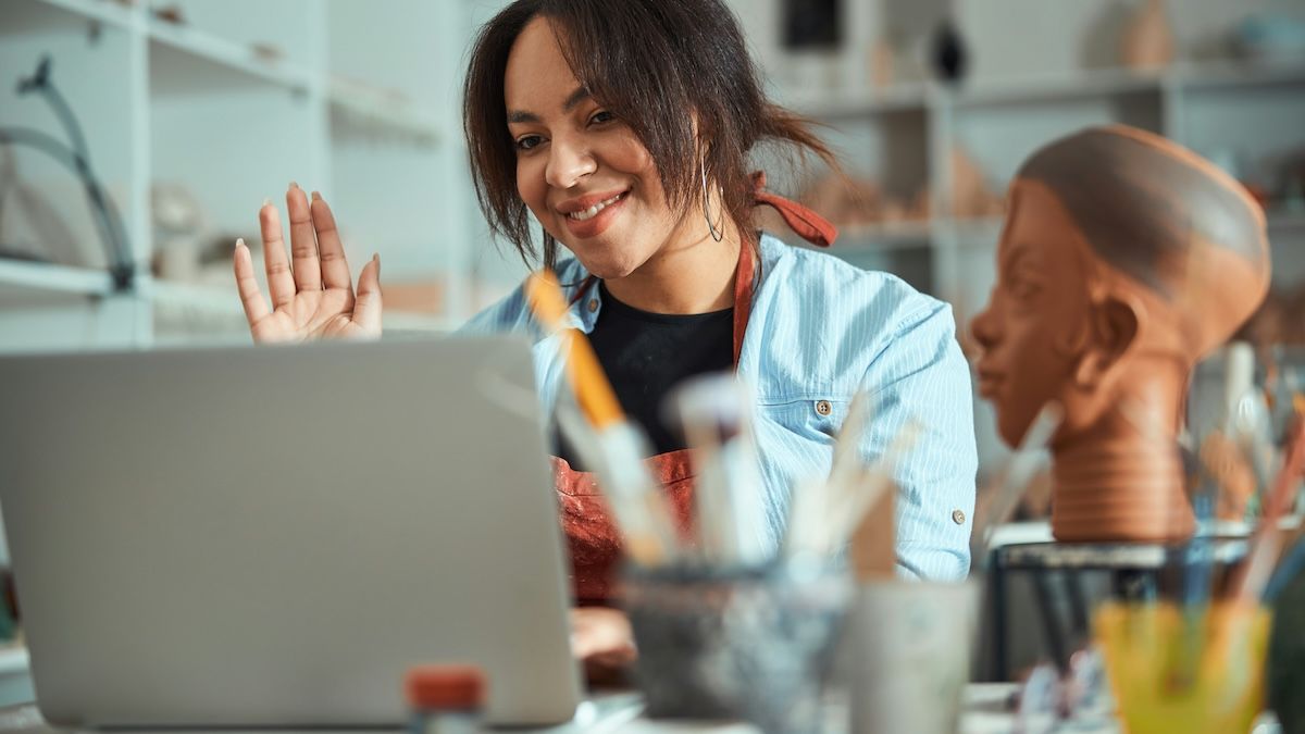 A art therapist waves hello to a client at the start of an online art therapy session.