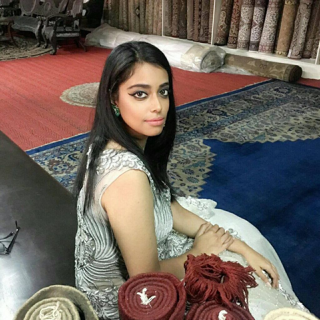 Vartika, seated on a bench, looking over her shoulder at the camera.