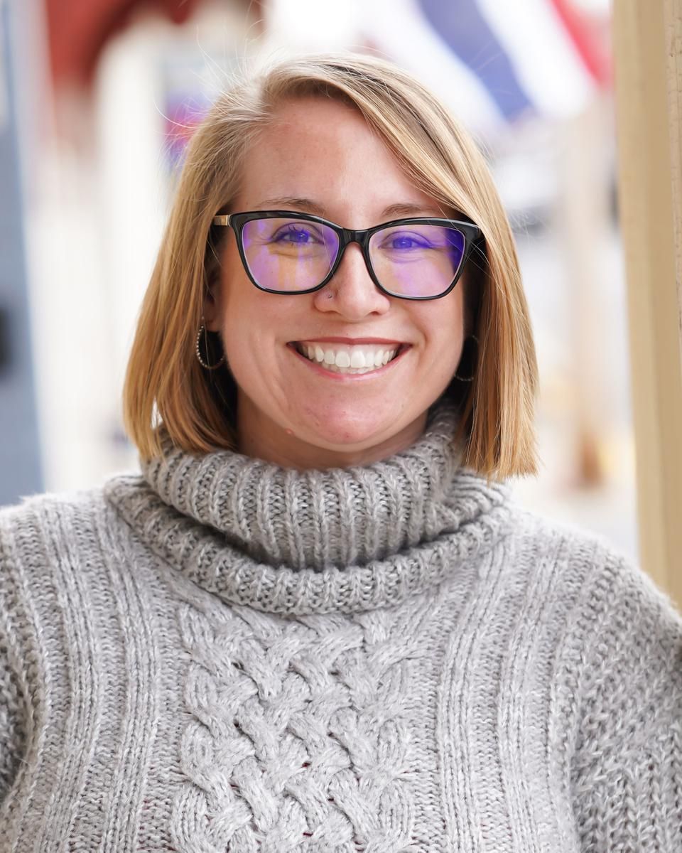 Alma therapist Meagan Faraone smiling to camera in a grey knit sweater.