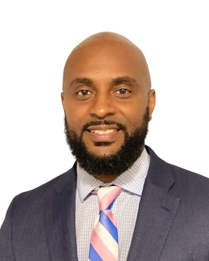 Alma therapist Dameon Clay, smiling to camera, wearing a dark suit.