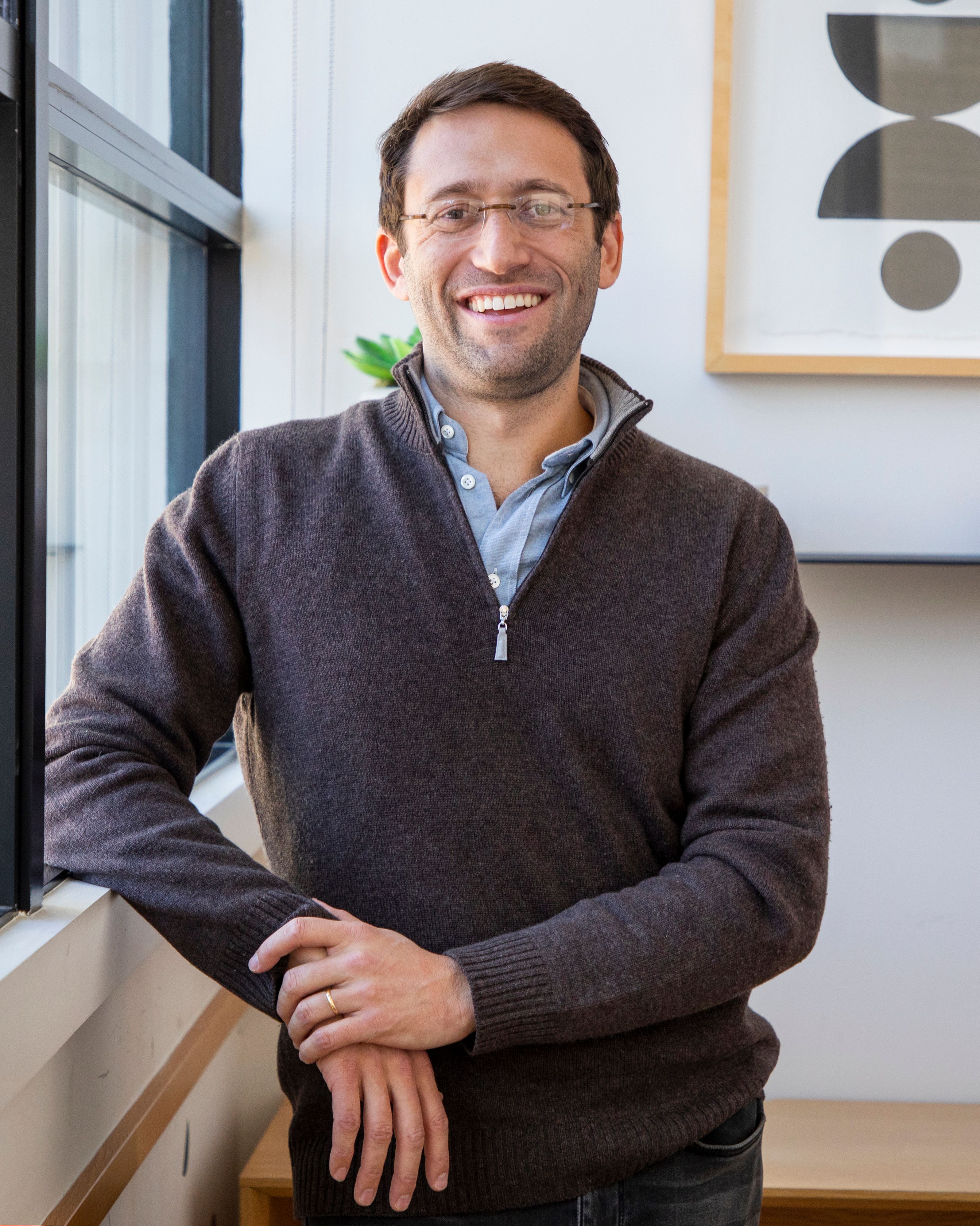 Alma CEO Harry Ritter leaning up against a windowsill in Alma's photogenic Brooklyn headquarters.