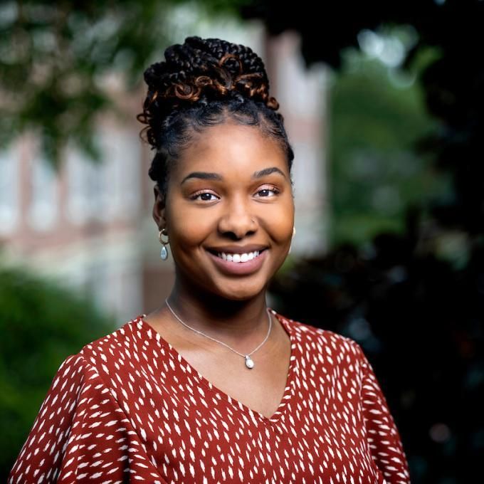 Alma therapist Alexis Fintchre smiling under the shade of a tree.