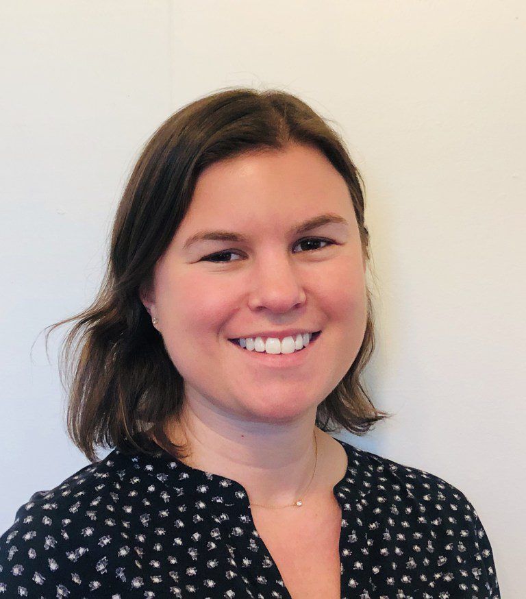 Allison Becker, a registered nurse with straight, shoulder-length brown hair, smiles to the camera.