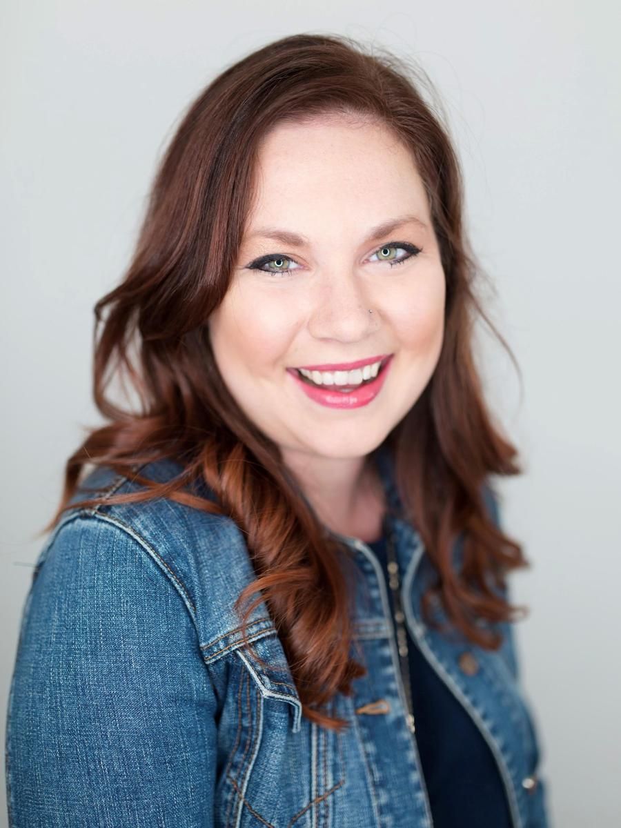 A slick headshot of Alma therapist Laura Brassie, smiling to the camera against a light gray backdrop.