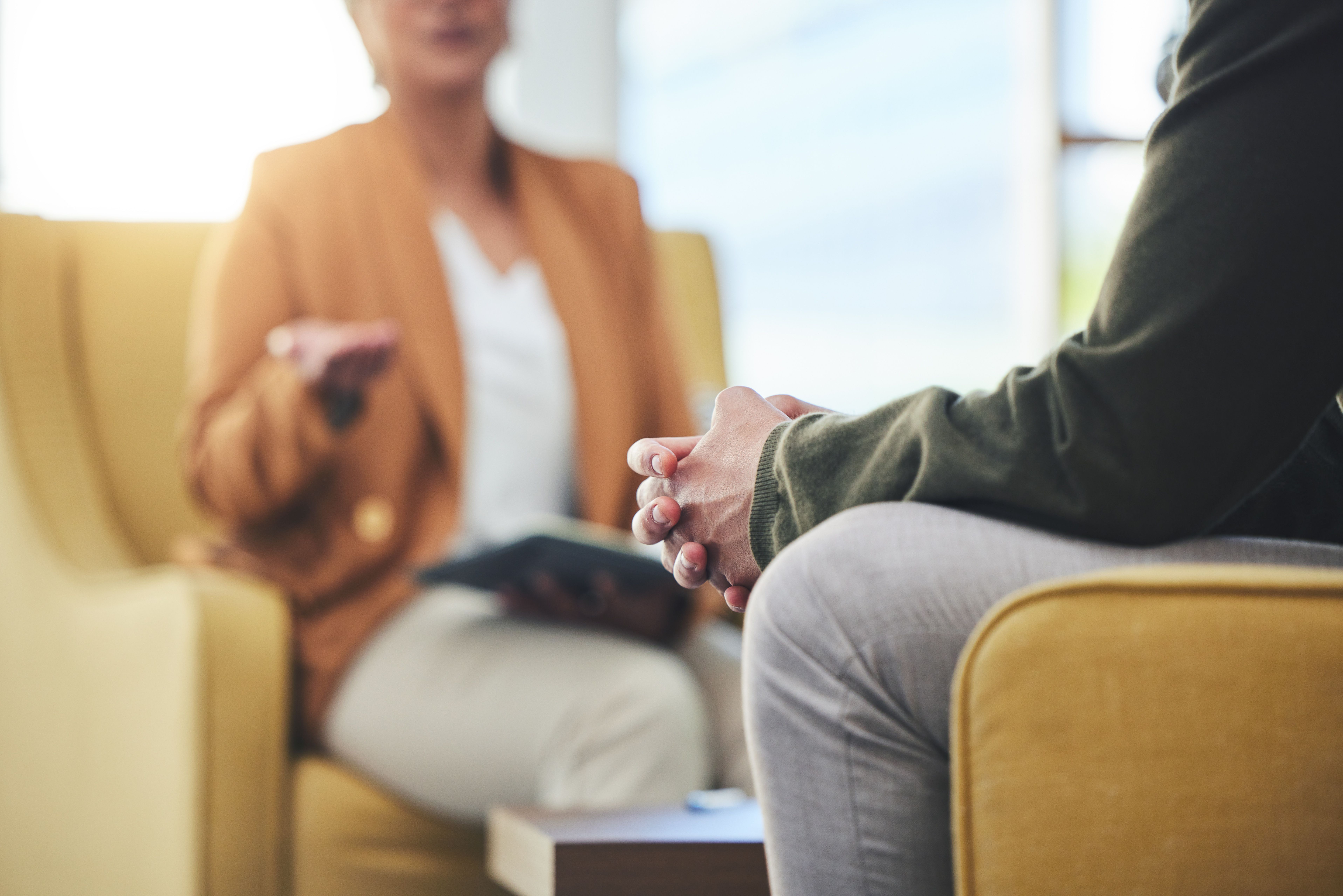 A clinician sits with their patient in a therapy session 