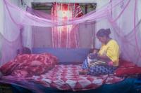 Devi Kannya Katayata (33) breastfeeds her son Nehan Budha (2) under a mosquito net in their home. | DER GREIF