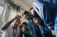Dr. Ishan Gautam shows Aedes larvae to students. | DER GREIF