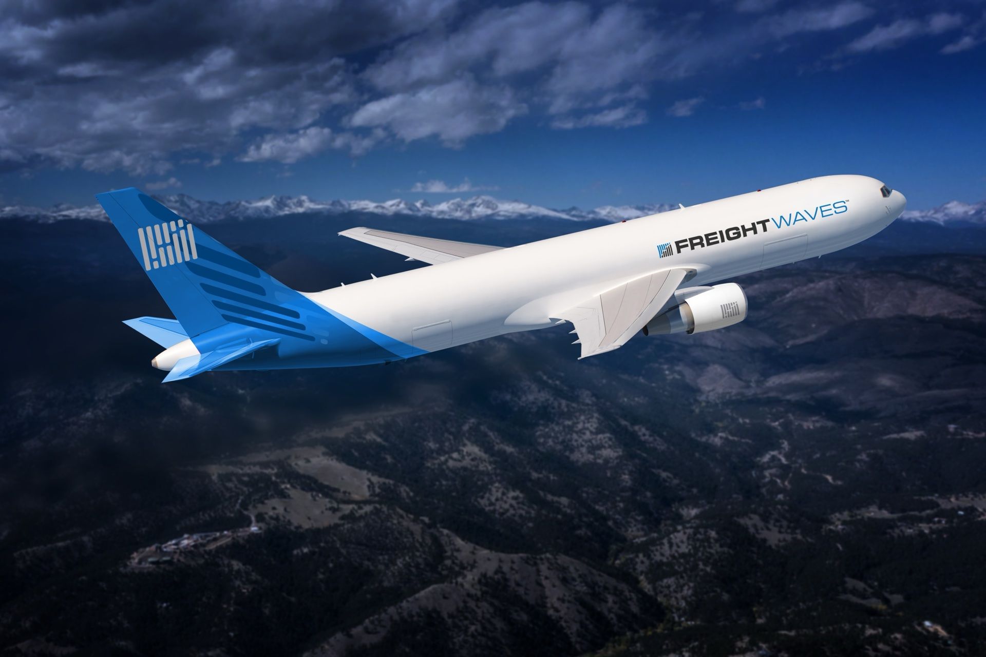 Air freighter with a FreightWaves-branded tail banking over mountains