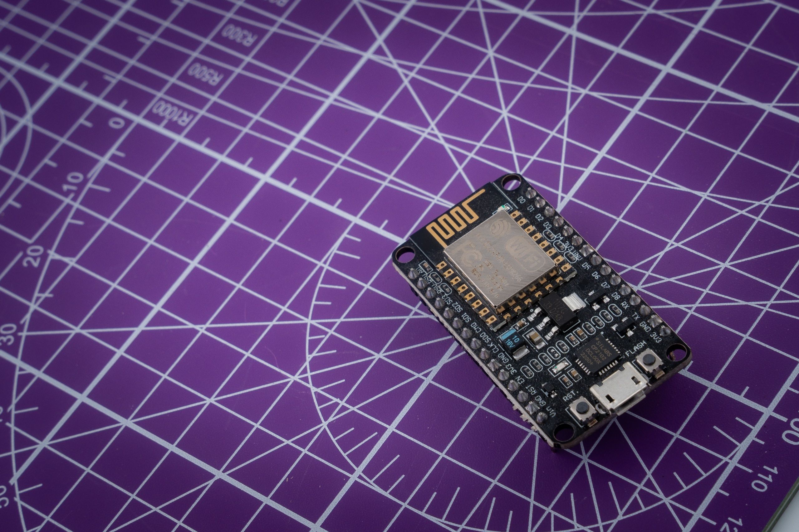 ESP8266 development board lying on a purple cutting mat
