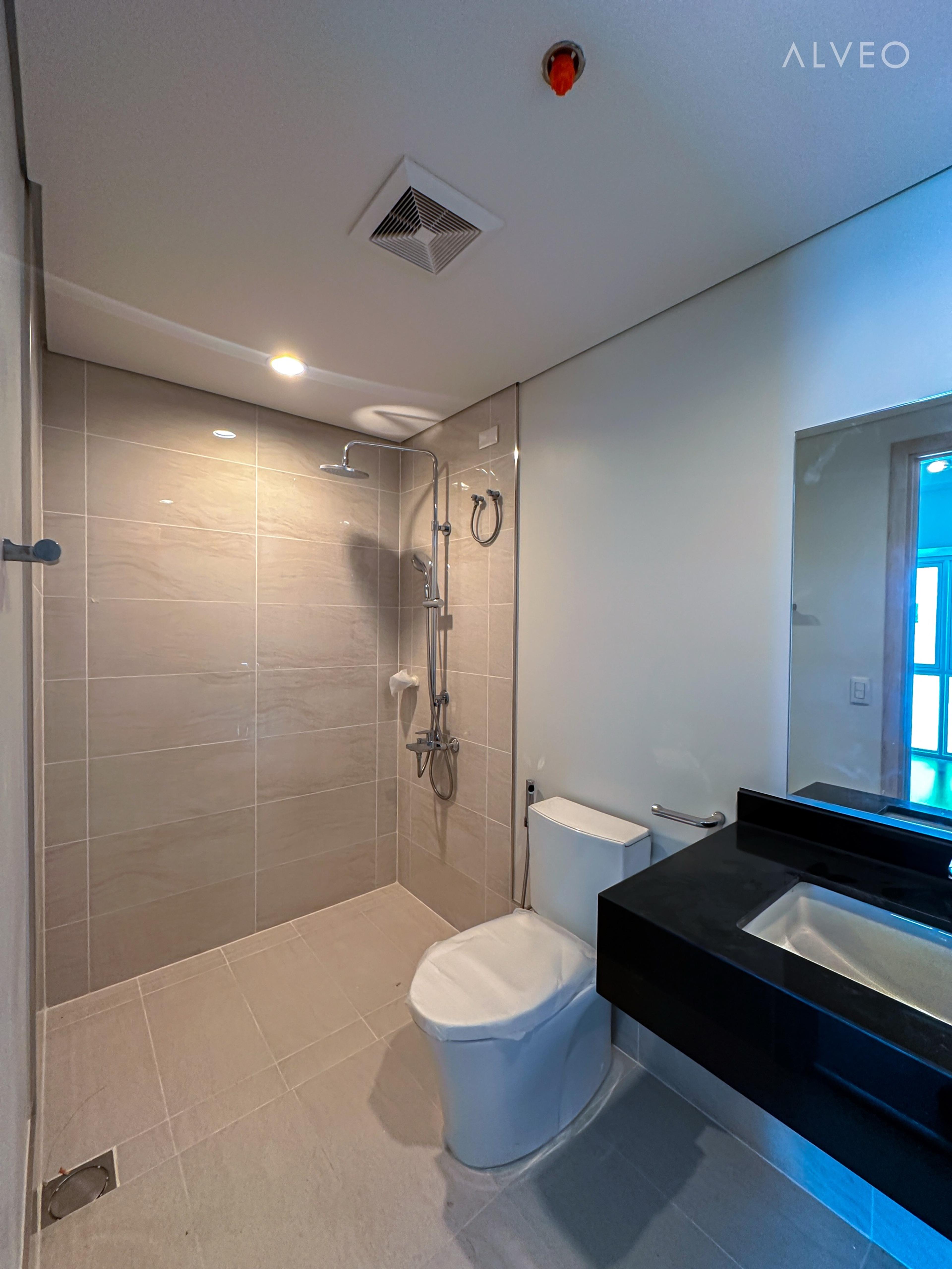 Cerule at Solinea two-bedroom unit bedroom with engineered wood flooring, built-in cabinetry and an ensuite toilet and bath
