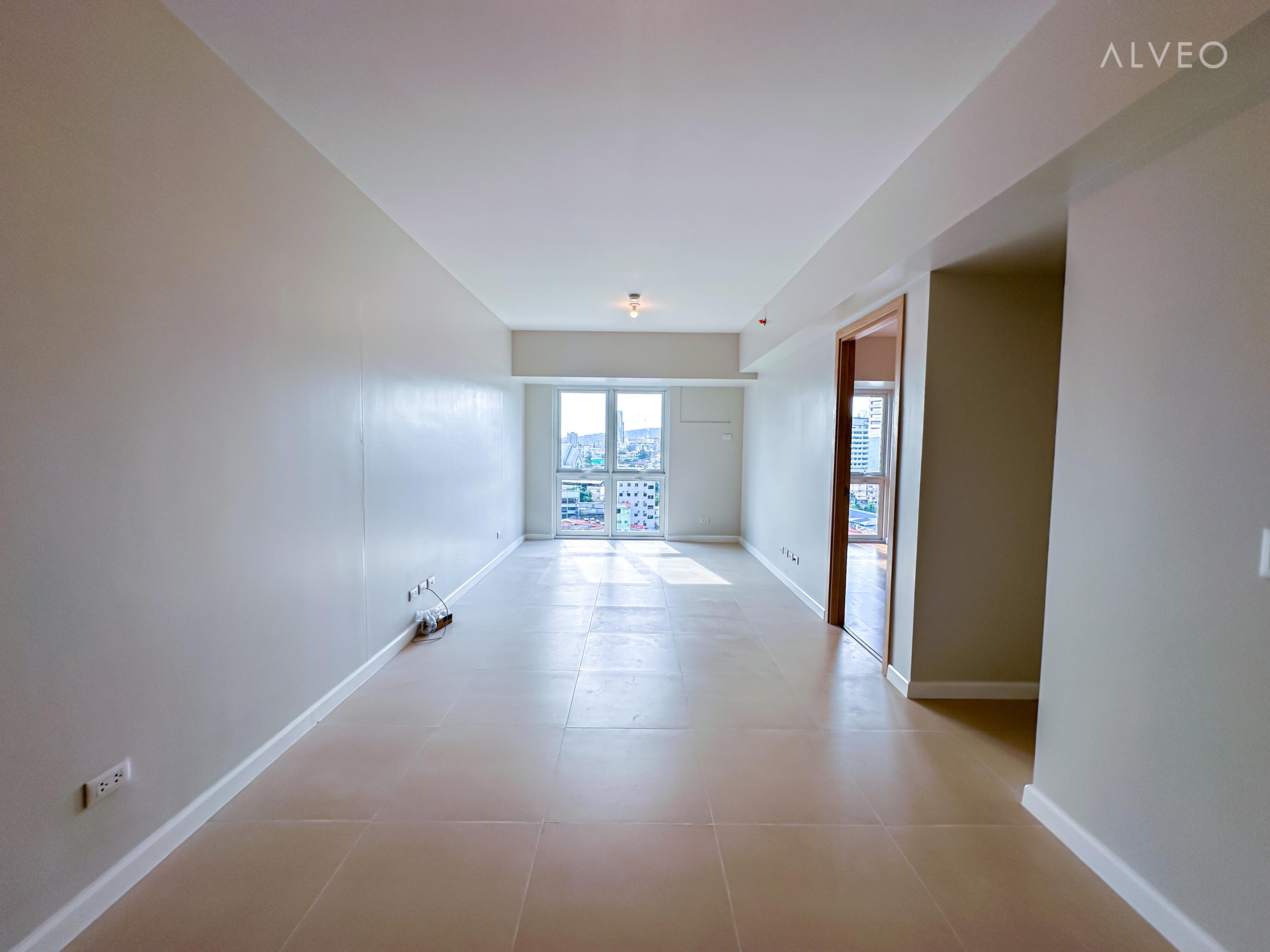 Cerule at Solinea one-bedroom unit living area at turnover, with tiled floor, balcony door and a city view