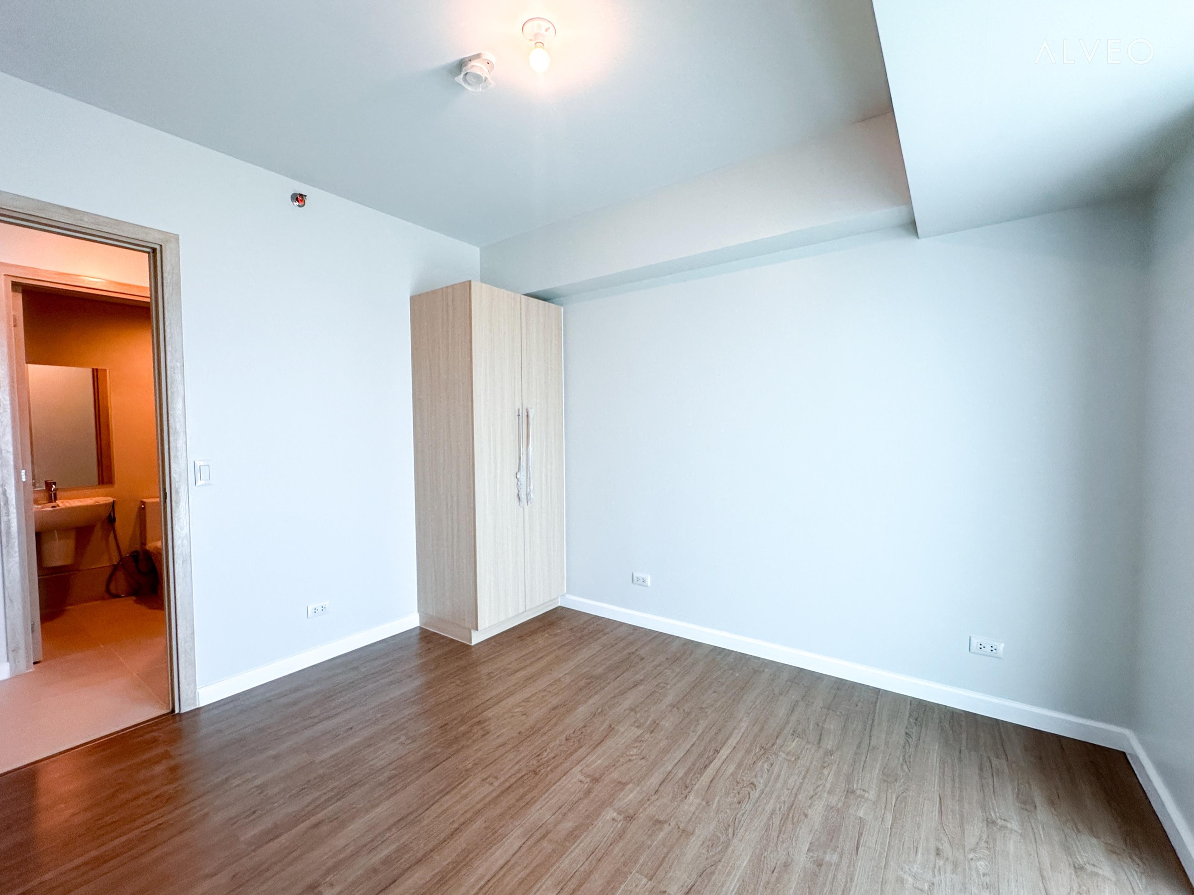 Cerule at Solinea three-bedroom unit bedroom at turnover, with a large picture window and engineered wood flooring