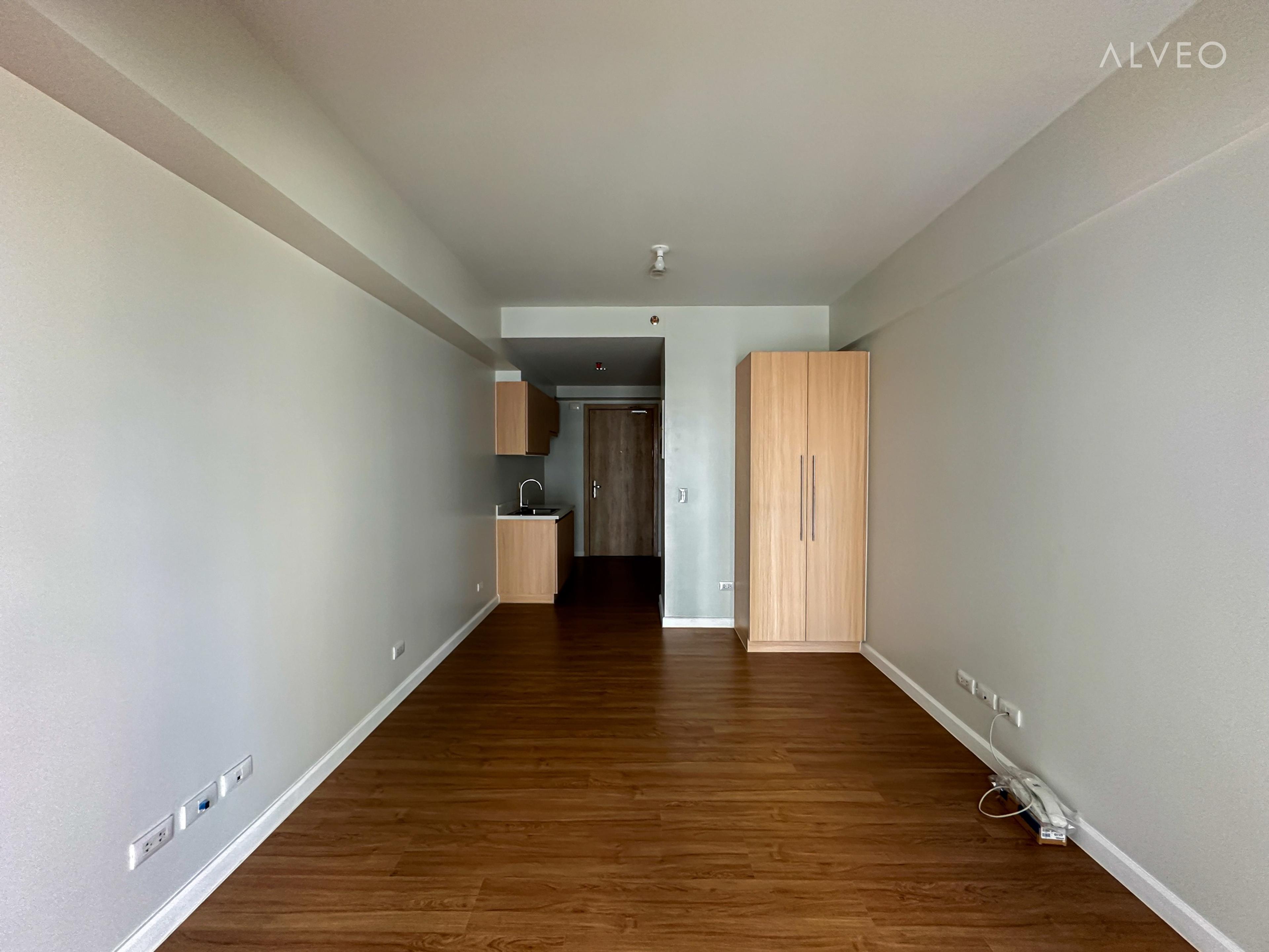 Cerule at Solinea studio unit showing the built-in wardrobe and compact kitchen counter near the entry door