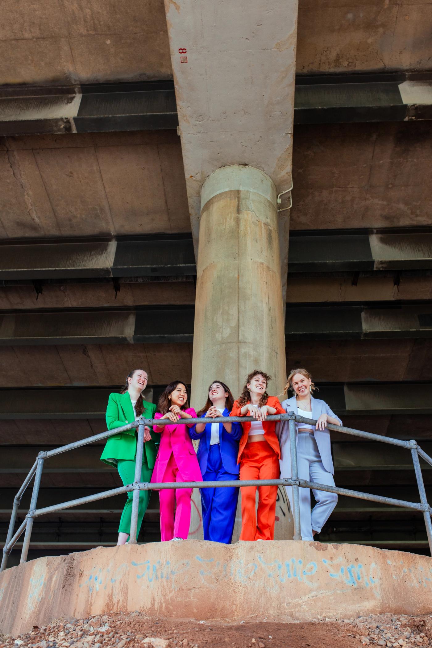 Sekine Quartet Hero Image - Sekine quartet standing on a pillar in brightly coloured suits