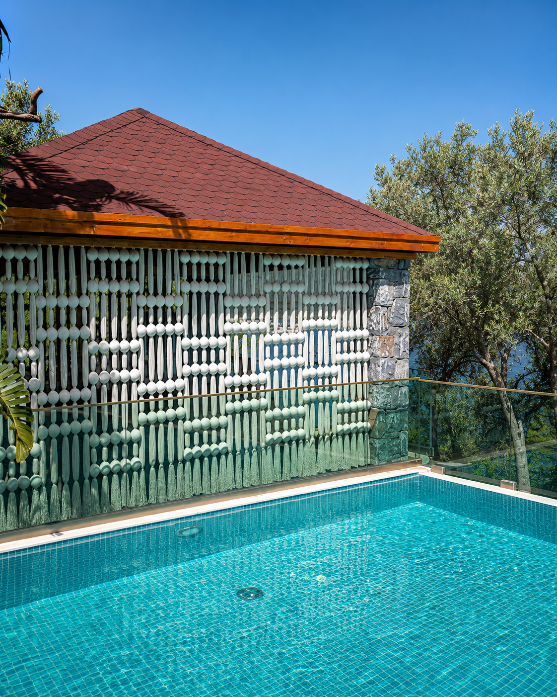 A cream patterned screen reflected in the turquoise pool beside a pavilion at Vogue Hotel Supreme Bodrum.