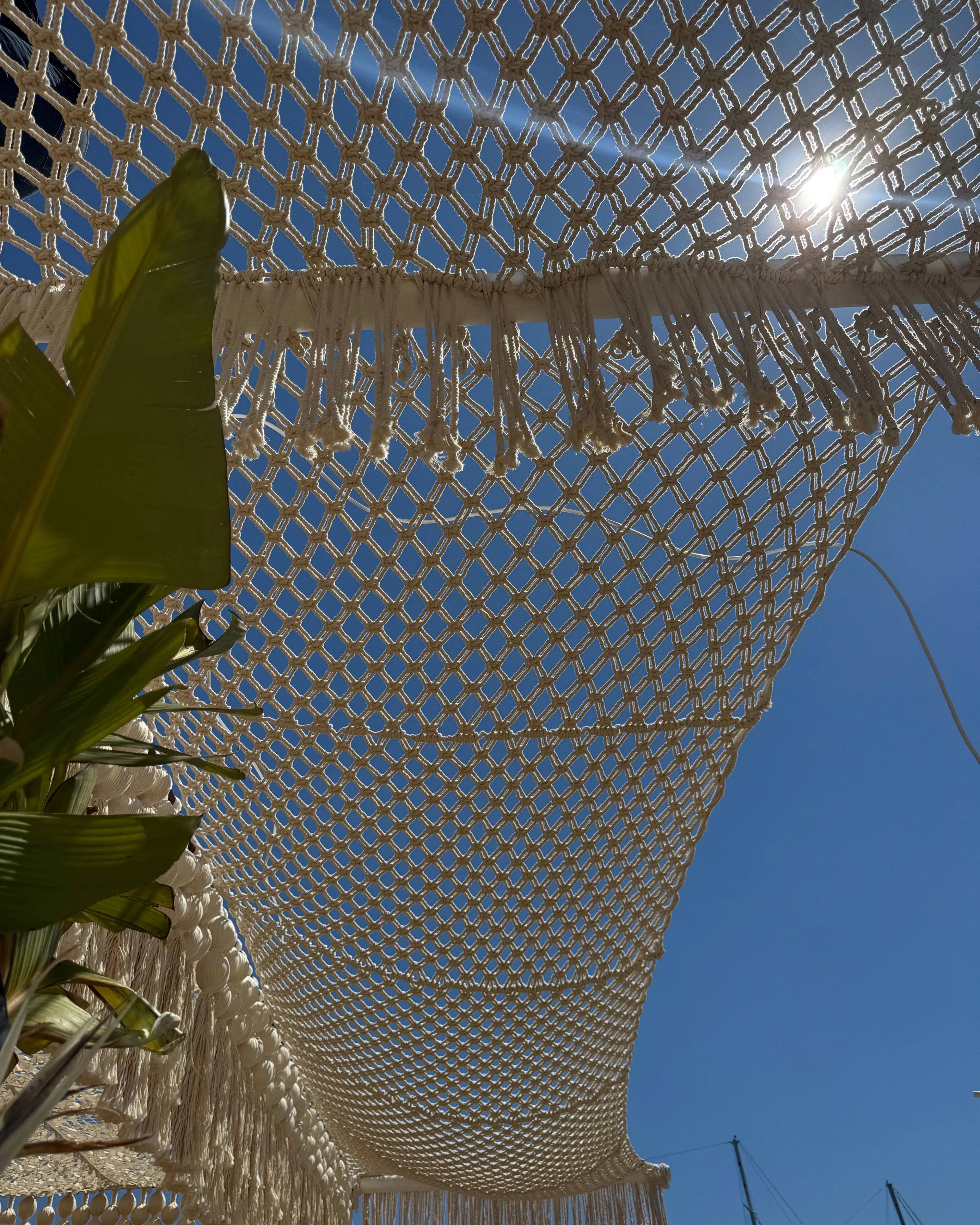 Open hand-knotted mesh of the shade canopy seen from below