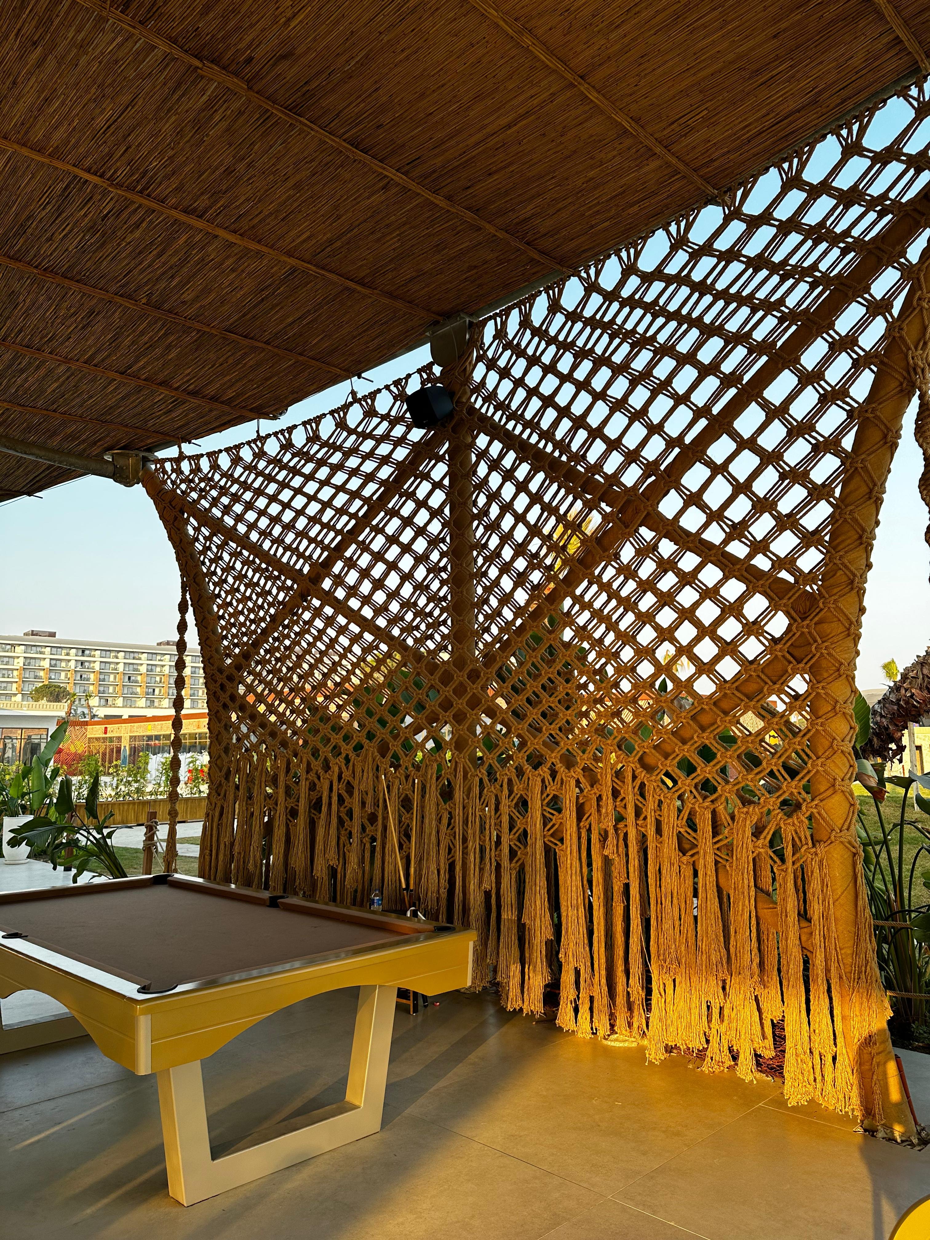 Dimare diamond-lattice macramé shade canopy with flowing fringe above the billiards terrace at Ethno Hotels Belek