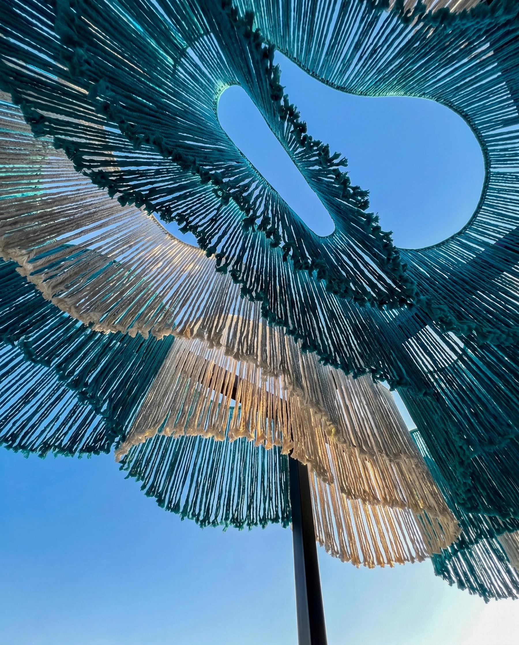 Looking up through the suspended turquoise and ecru fibres