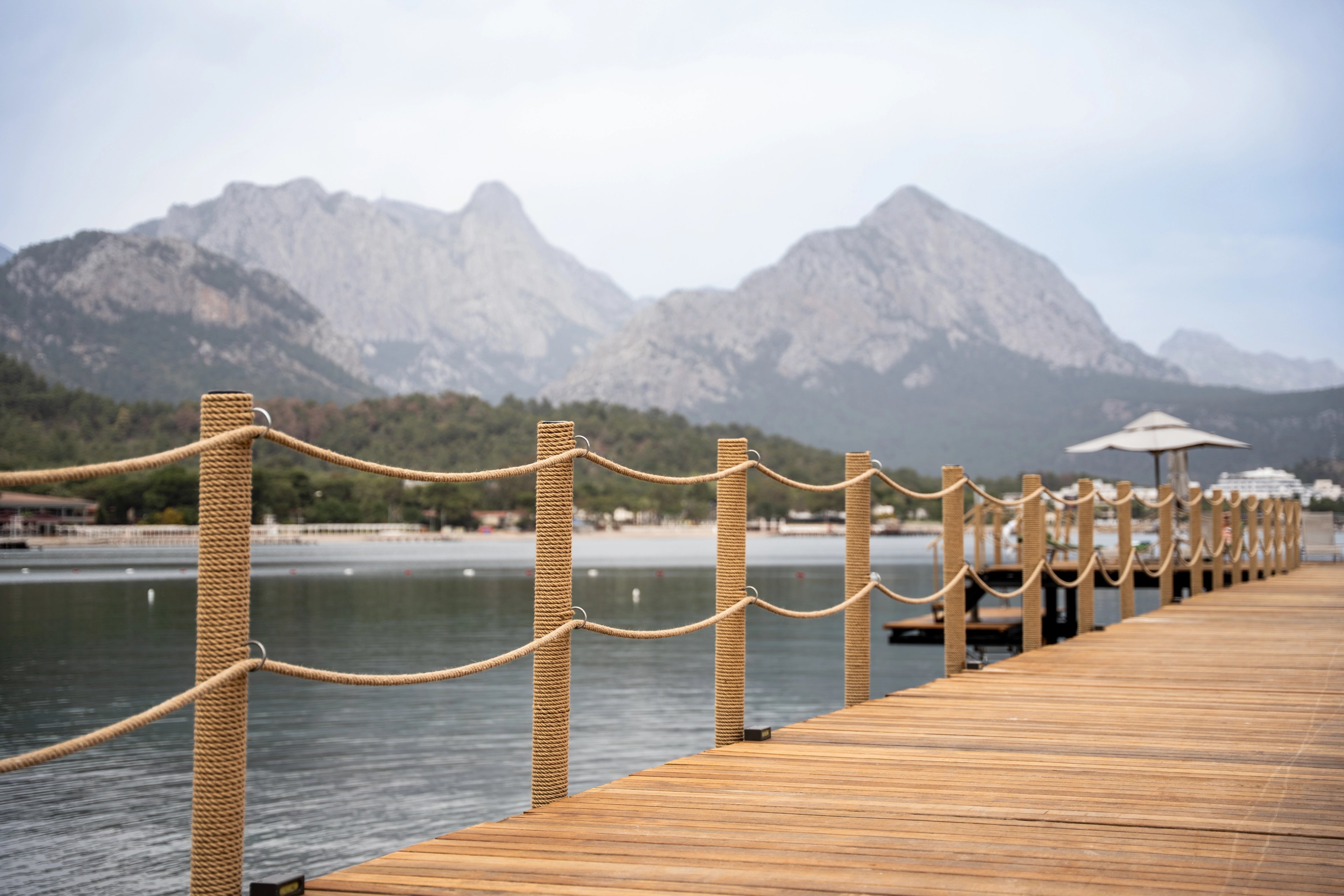 Rope-wrapped posts and parallel rope lines against the bay and mountain skyline at NG Phaselis Bay, 2025