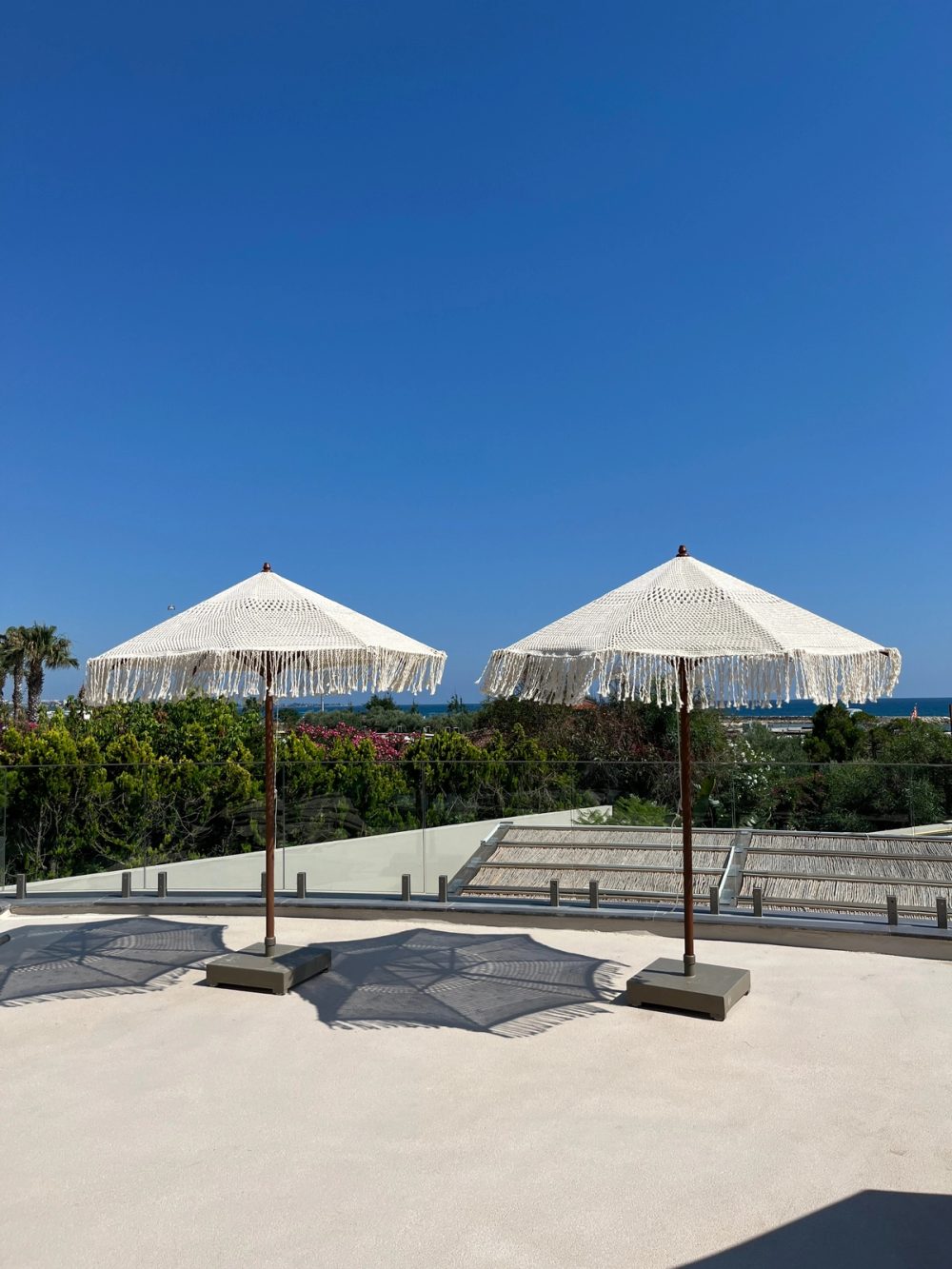 Macramé parasols on the Dimare four-wheel mobile base on a resort terrace above the sea