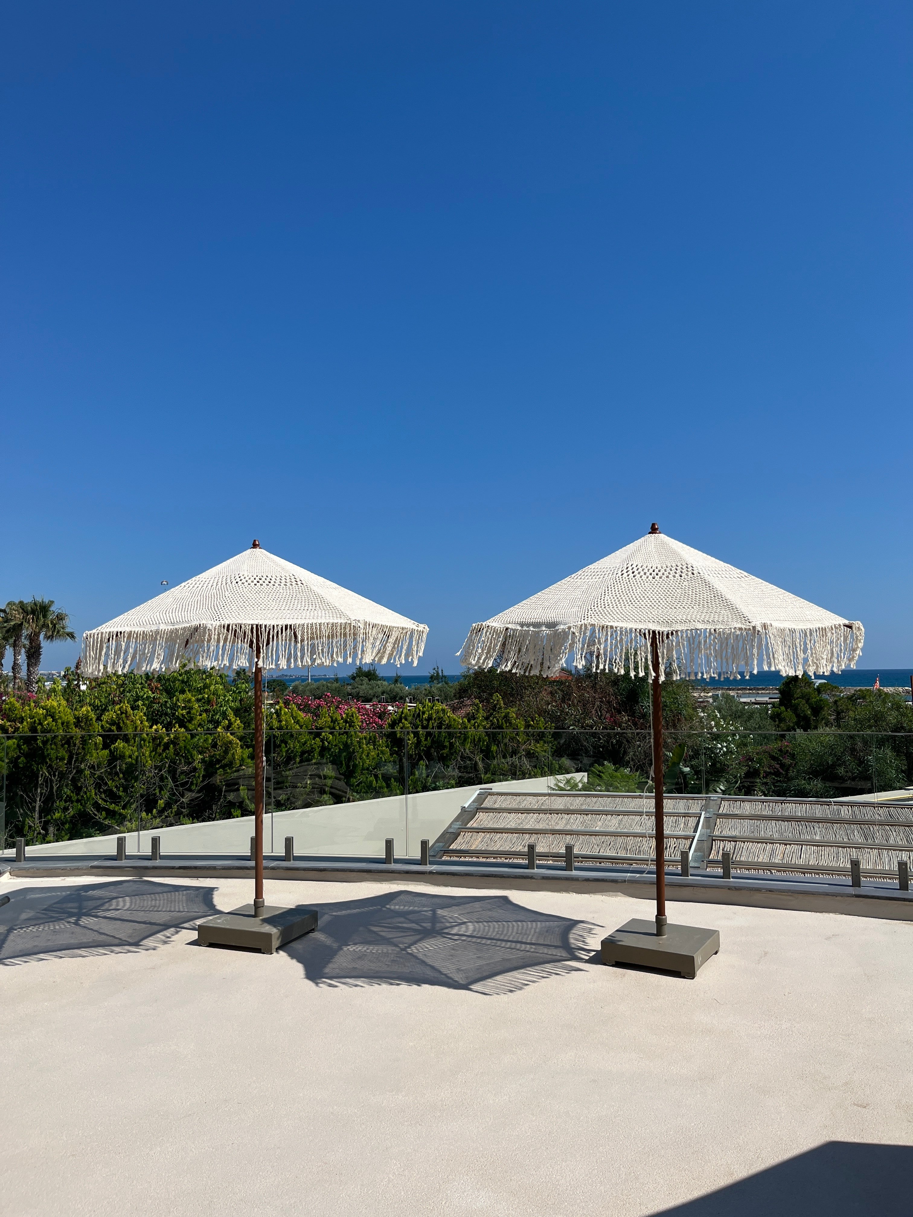 Macramé parasols on the Dimare four-wheel mobile base on a resort terrace above the sea