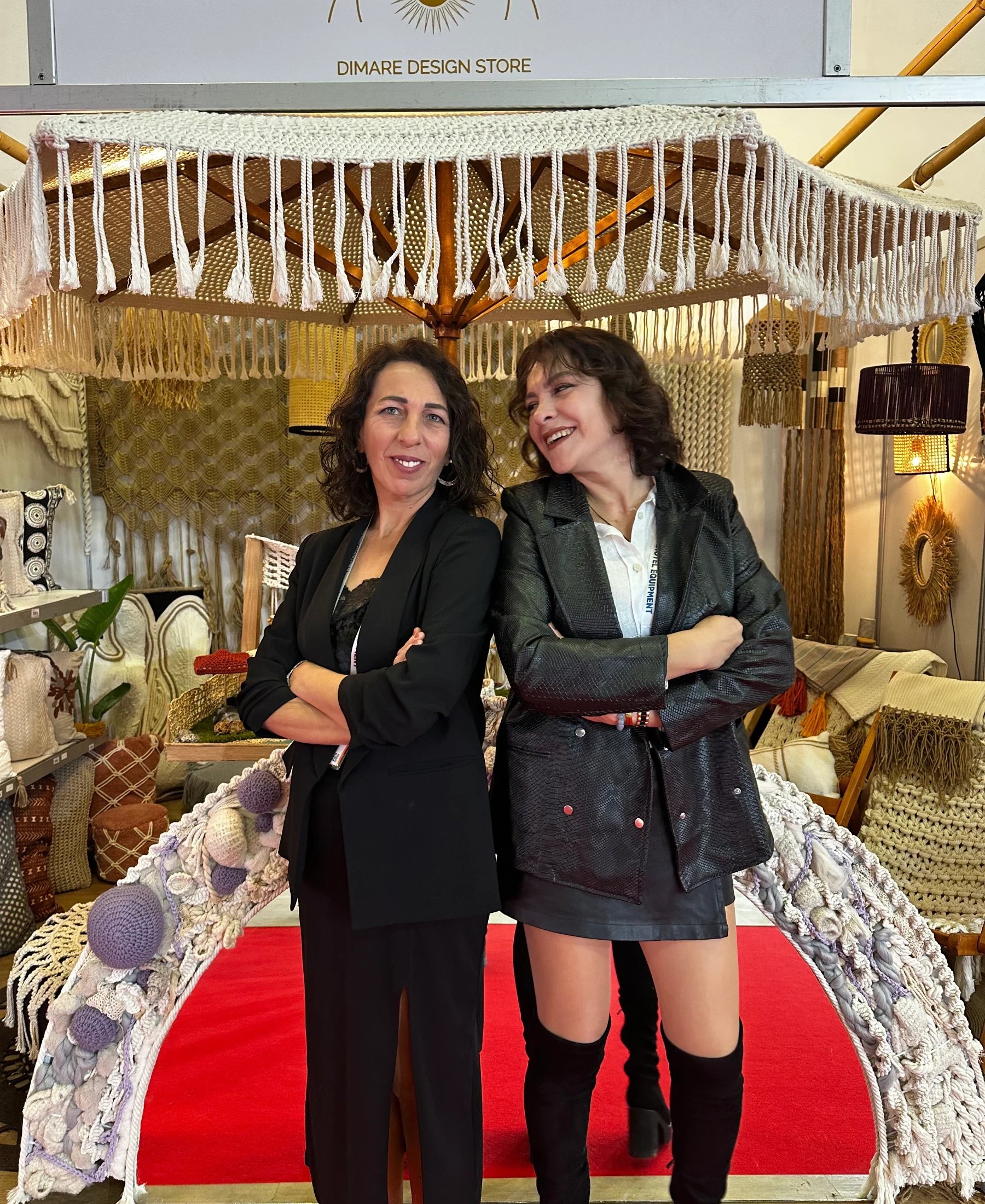 Two members of the Dimare family team at a display of handwoven décor.