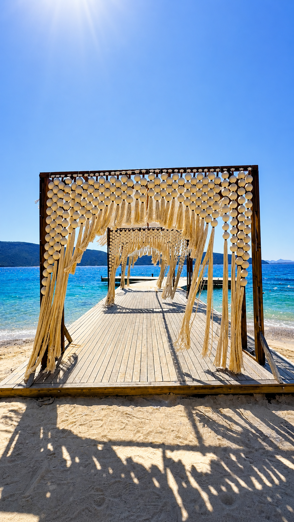 A succession of dark rectangular frames with cream sphere-and-tassel openings leading onto the jetty at TUI Magic Life Bodrum.