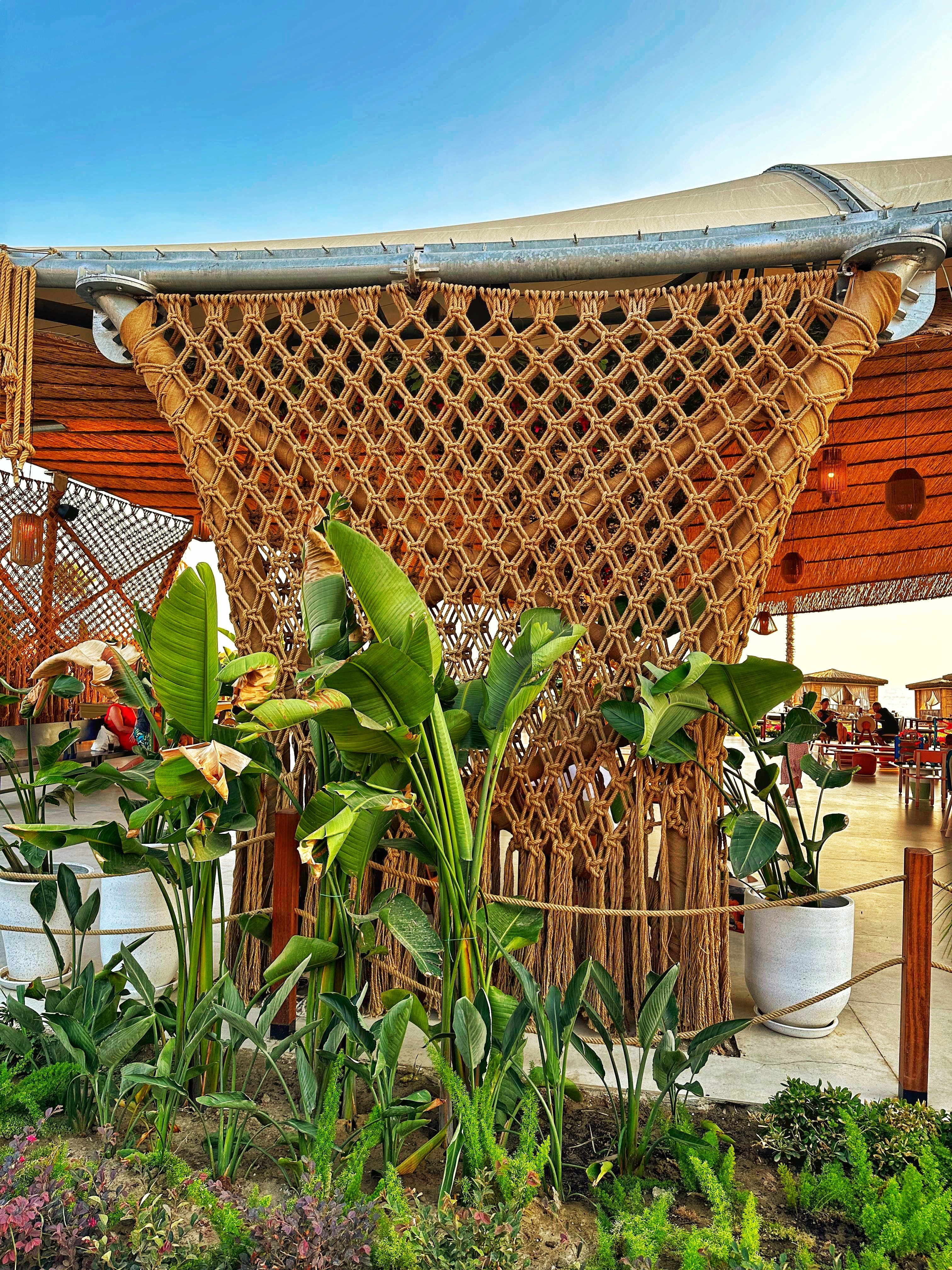 Dimare woven rope diamond-grid panel with cascading fringe set among tropical planting at Ethno Hotels Belek