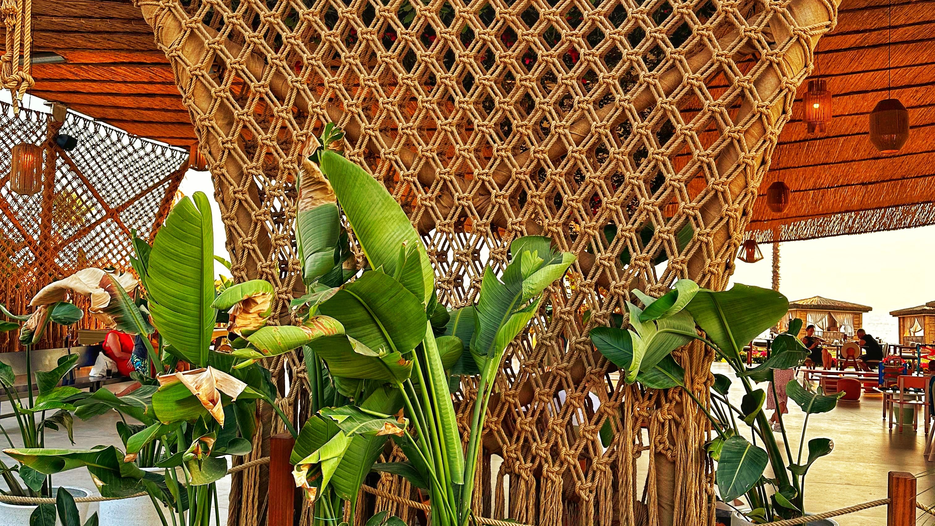 Dimare woven rope diamond-grid panel with cascading fringe set among tropical planting at Ethno Hotels Belek