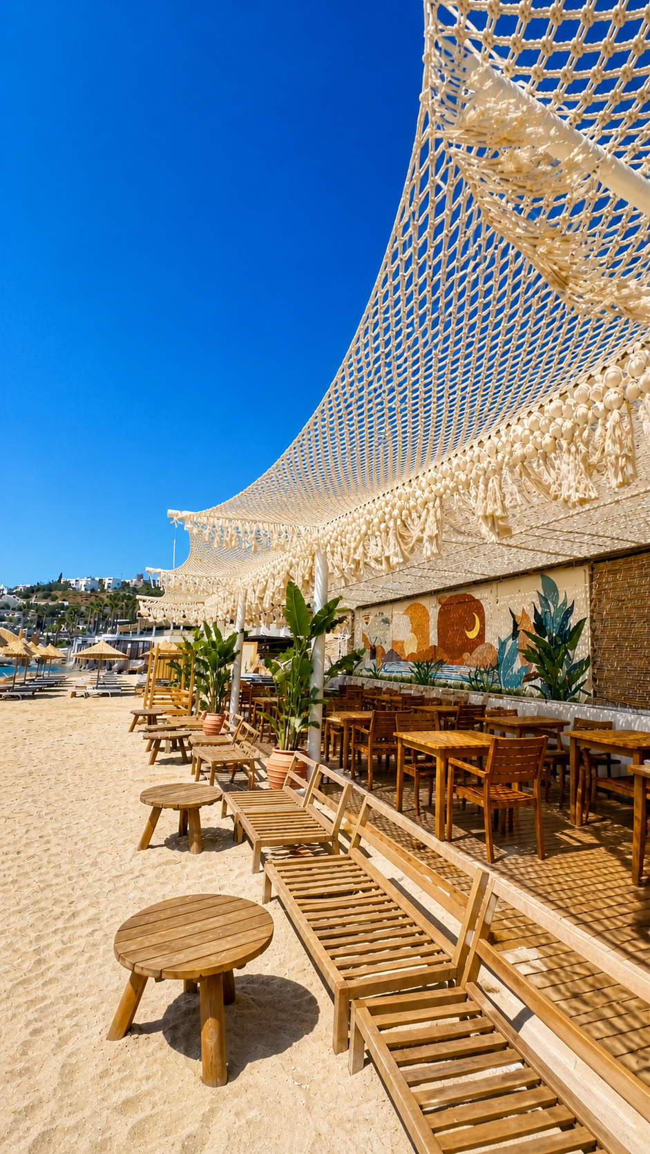 A draped open-net canopy with a fringed edge above a beachfront restaurant and loungers at TUI Magic Life Bodrum.
