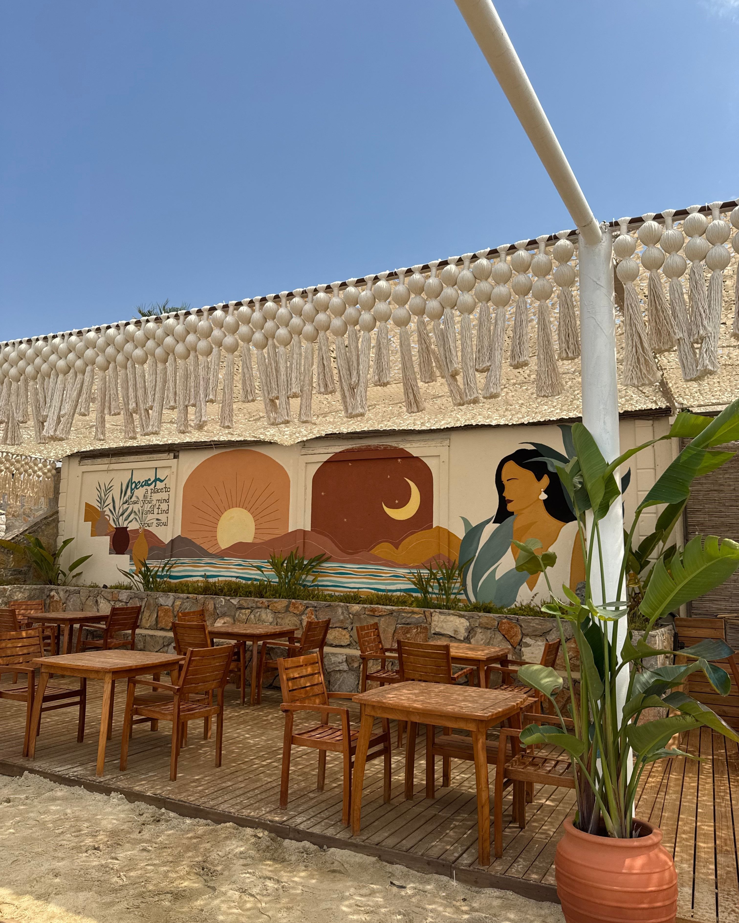 Mesh shade canopy with knotted fringe edging a beach restaurant terrace