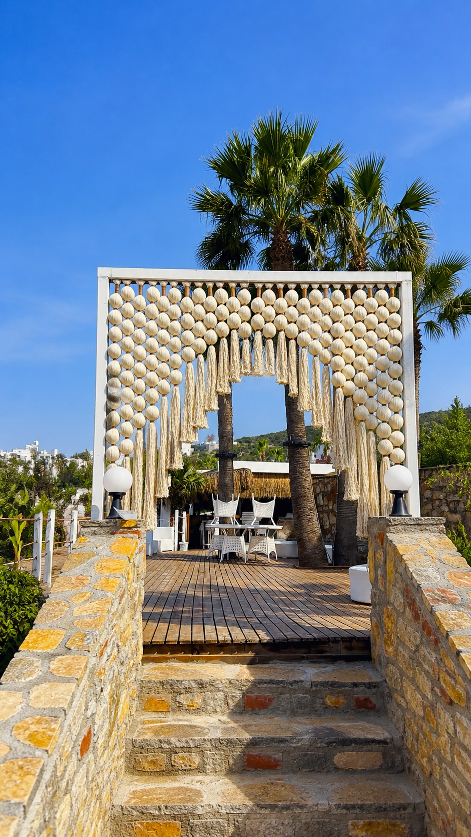 A cream sphere-and-tassel archway at the top of stone steps leading to a terrace at TUI Magic Life Bodrum.