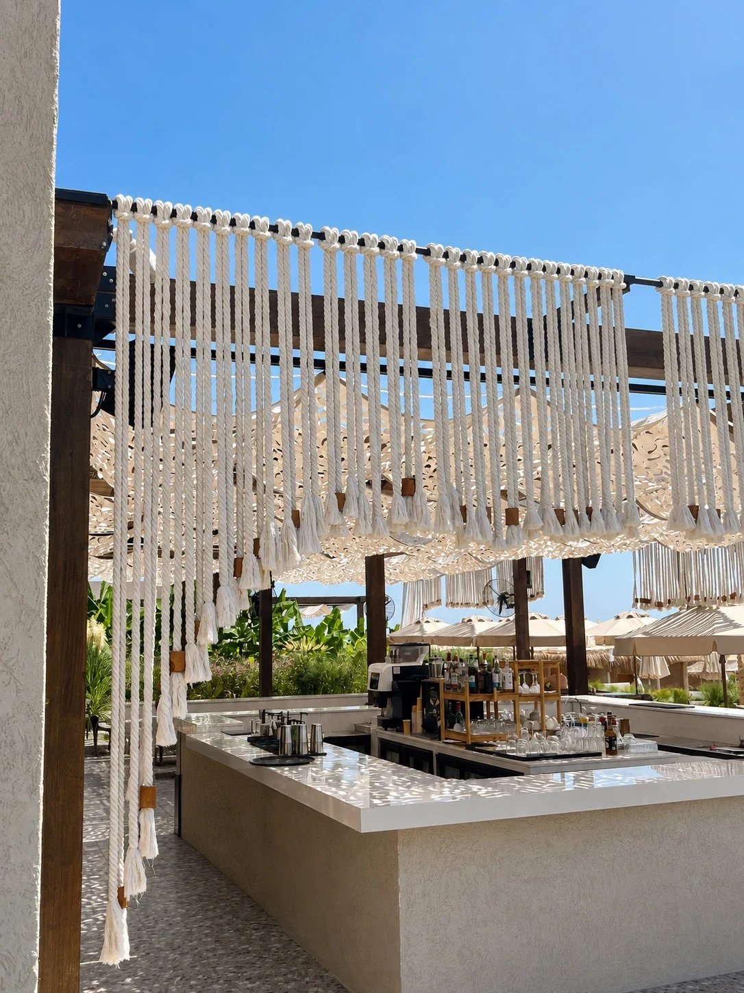 The Adalya Bliss bar counter framed by hanging panels of beaded rope fringe