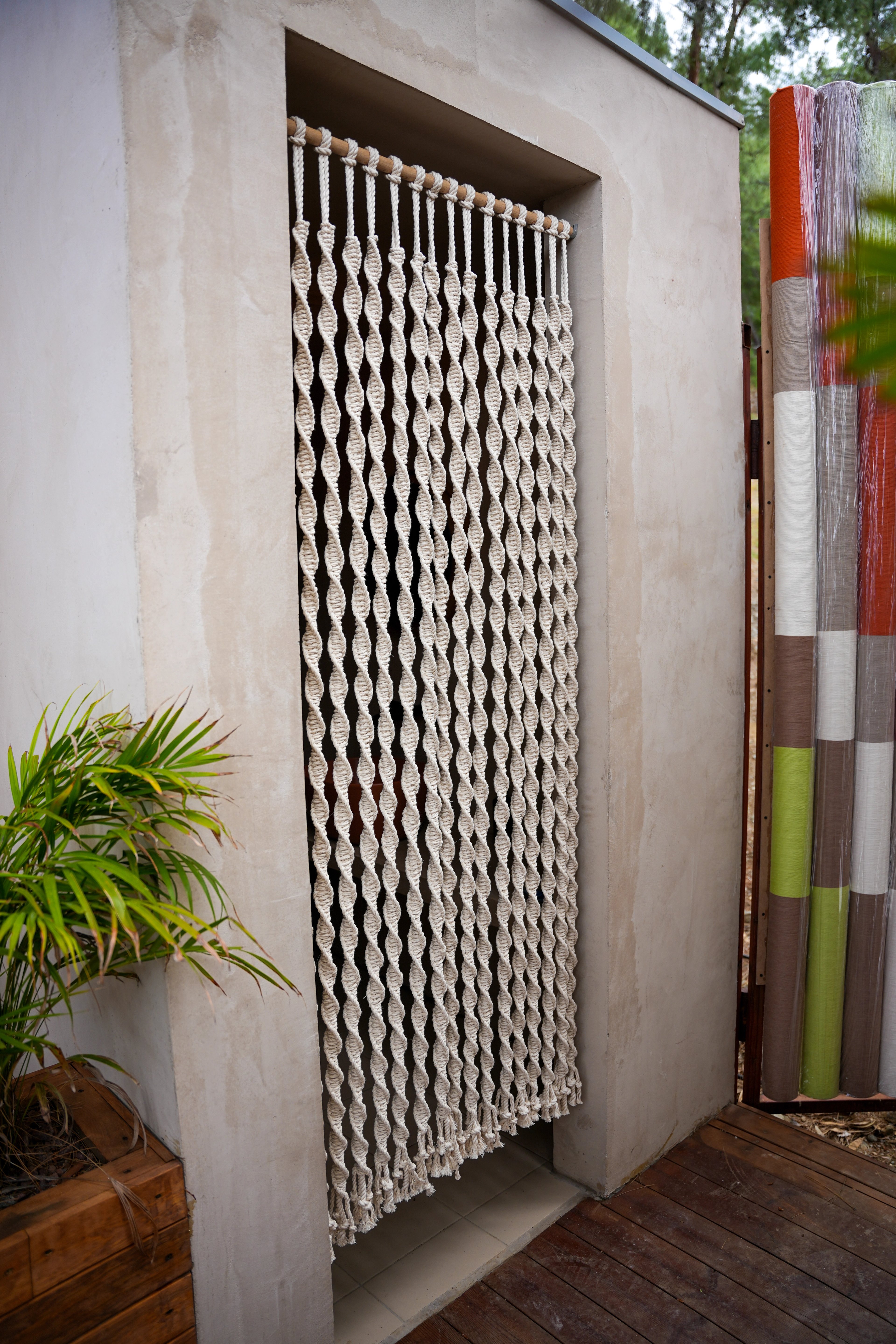 A cream twisted-rope curtain hanging within a rectangular wall opening at So Beach.