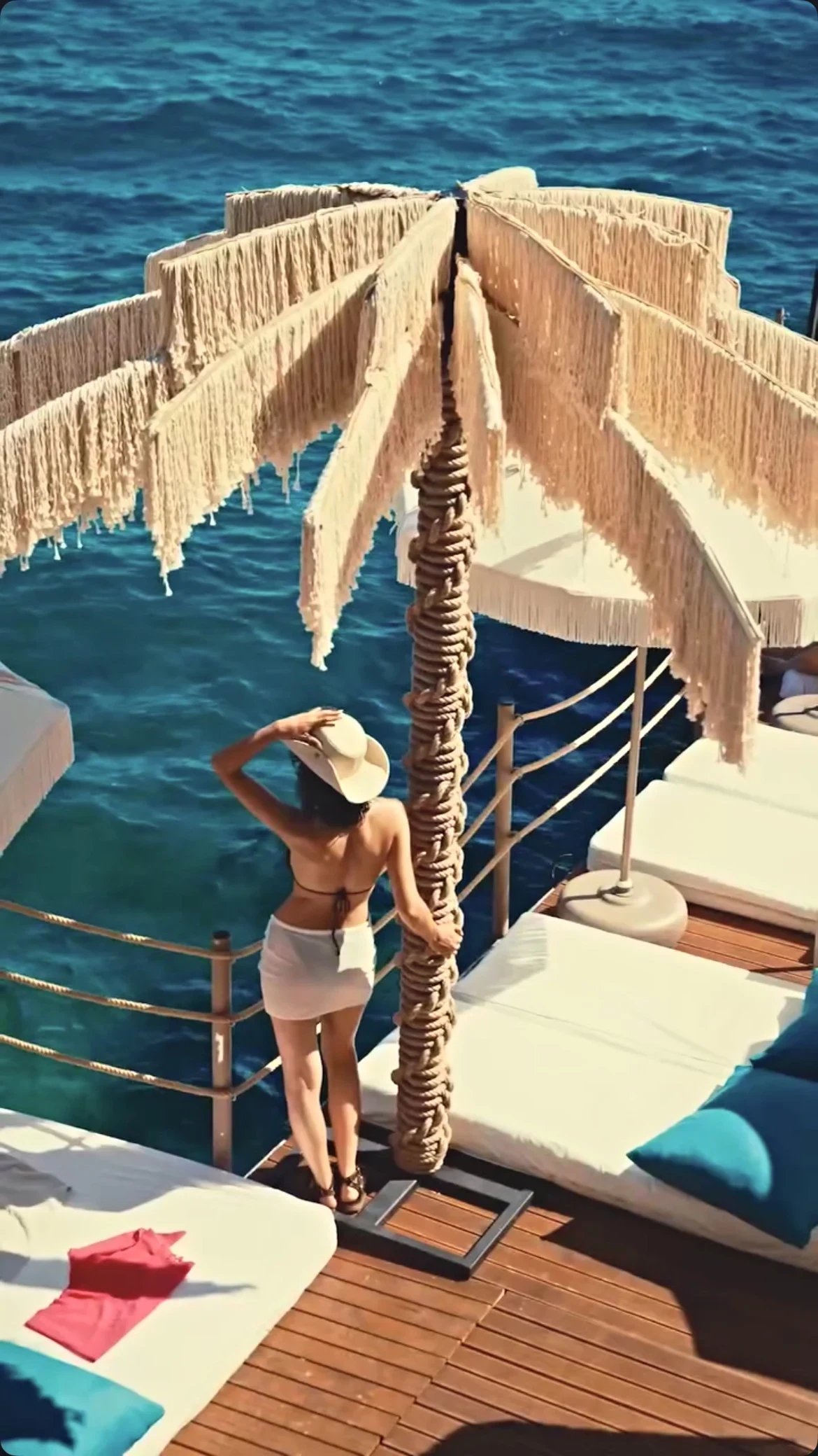 A Dimare Palm Tree with a braided rope trunk on the Bilem Beach deck above deep blue water