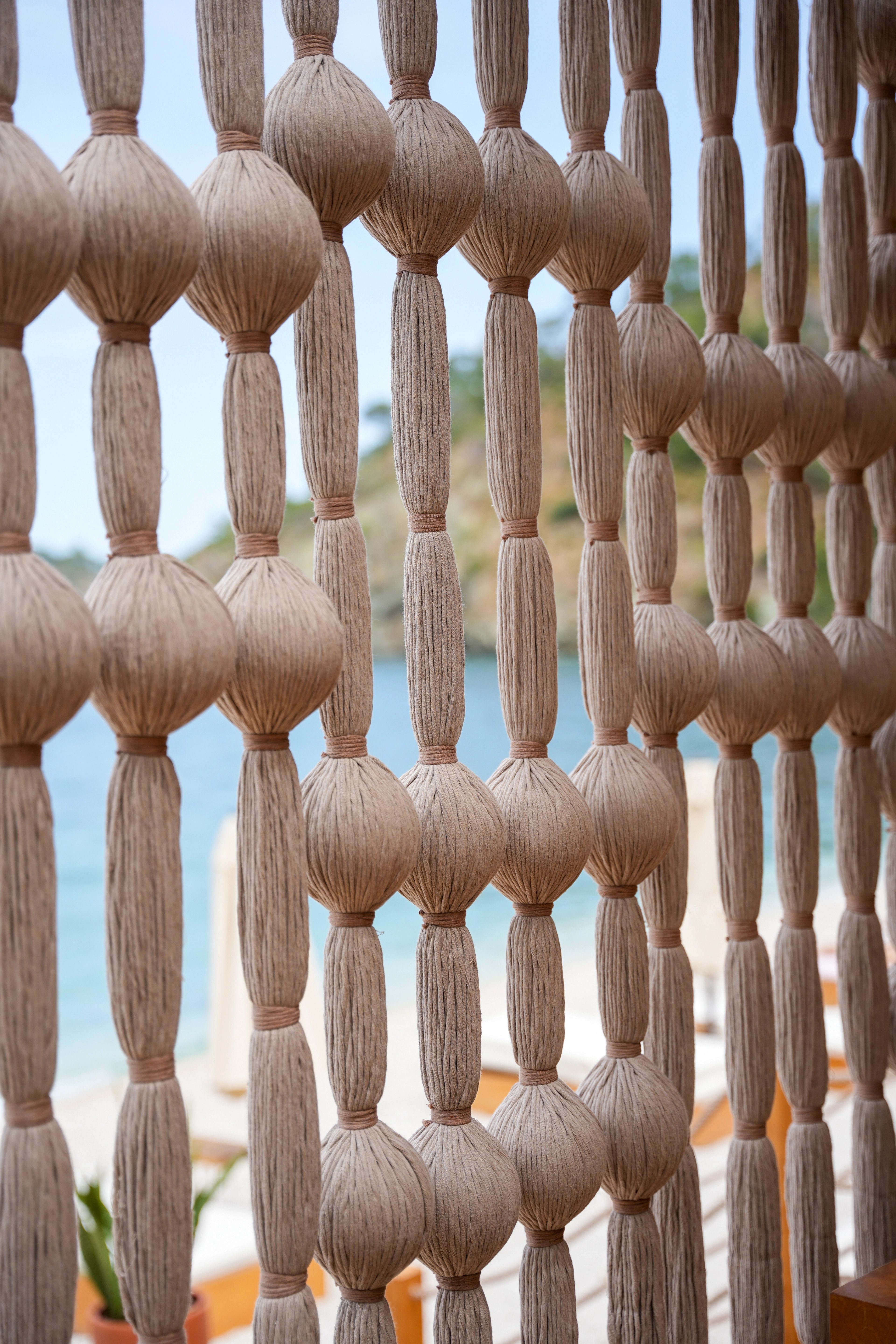 Close view of rounded wrapped forms connected by straight strands in a cream screen at So Beach.