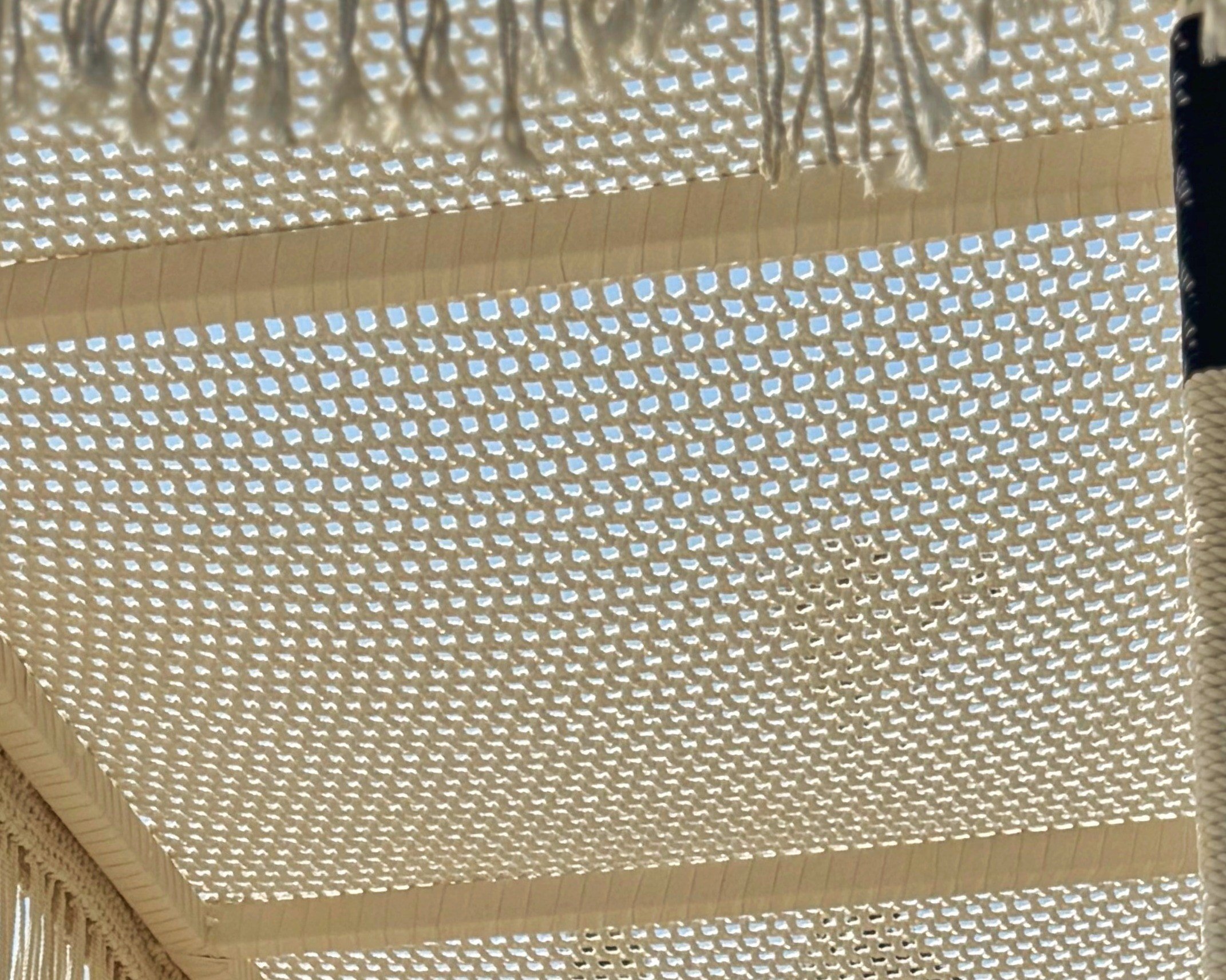 Close view of the hand-knotted mesh of a ceiling panel