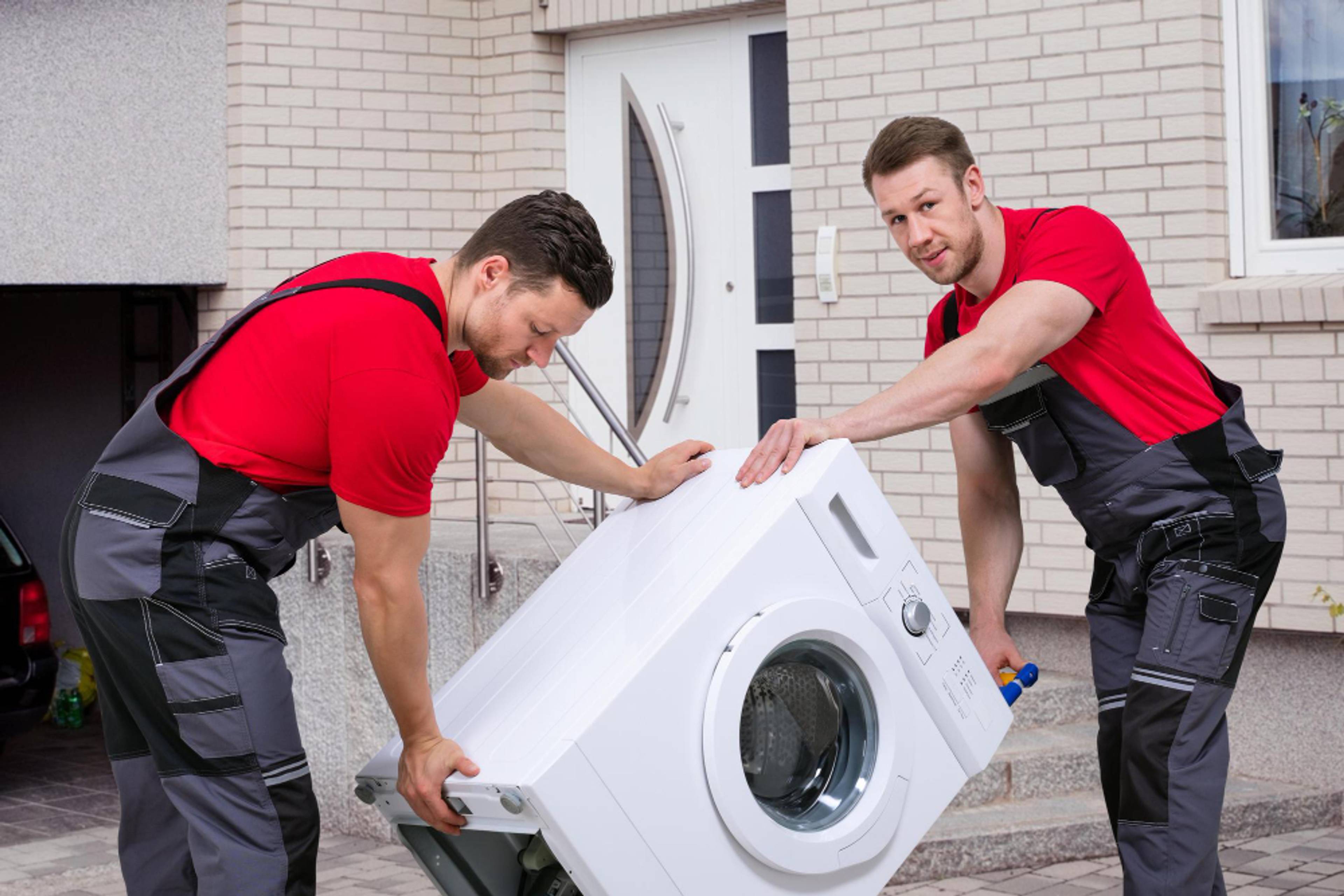 2 handymen moving a washing machine