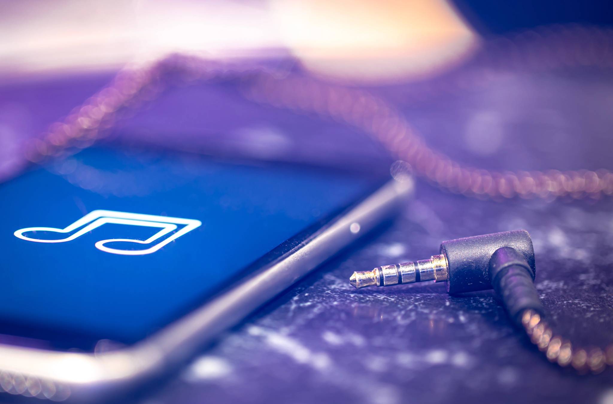 Music background with a music listening icon on the phone and headphones.