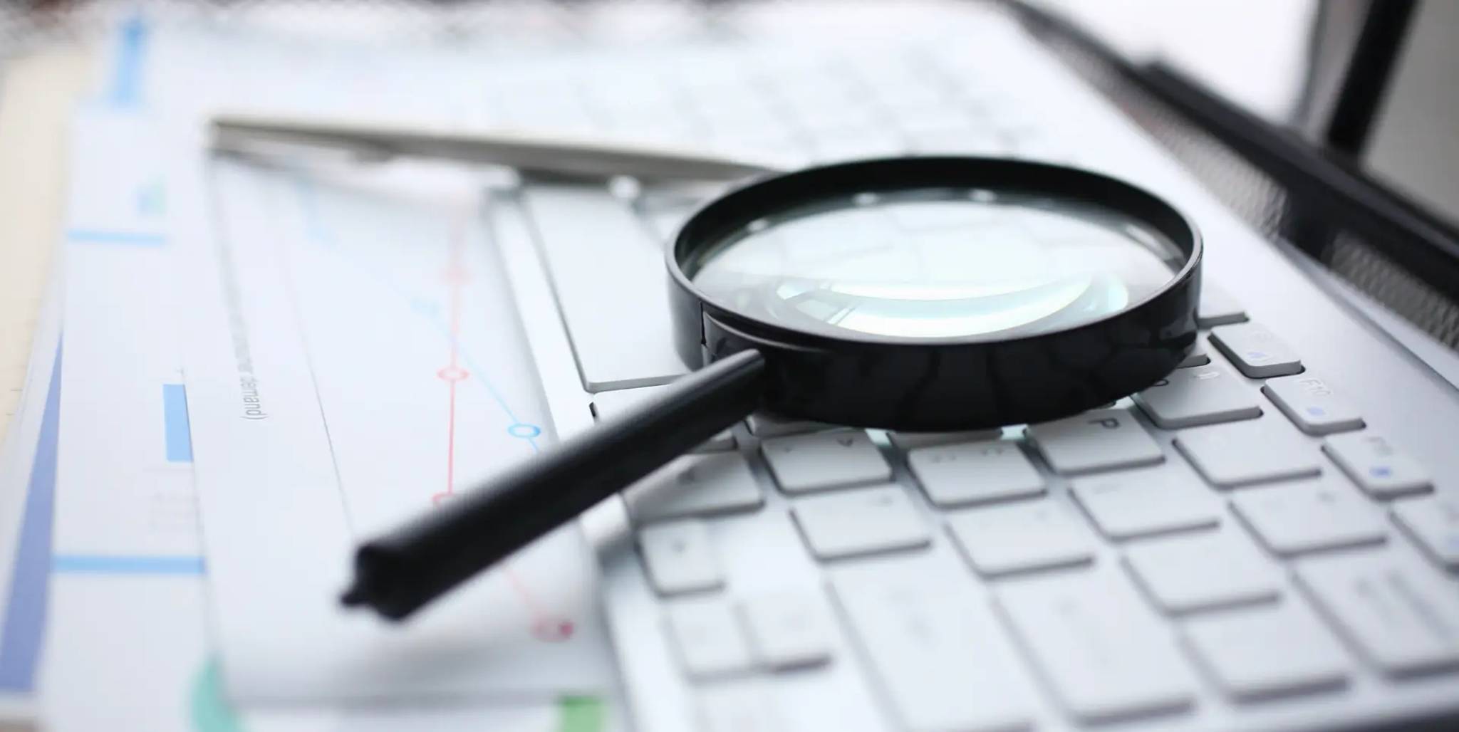 A magnifiying glass laying on a keyboard