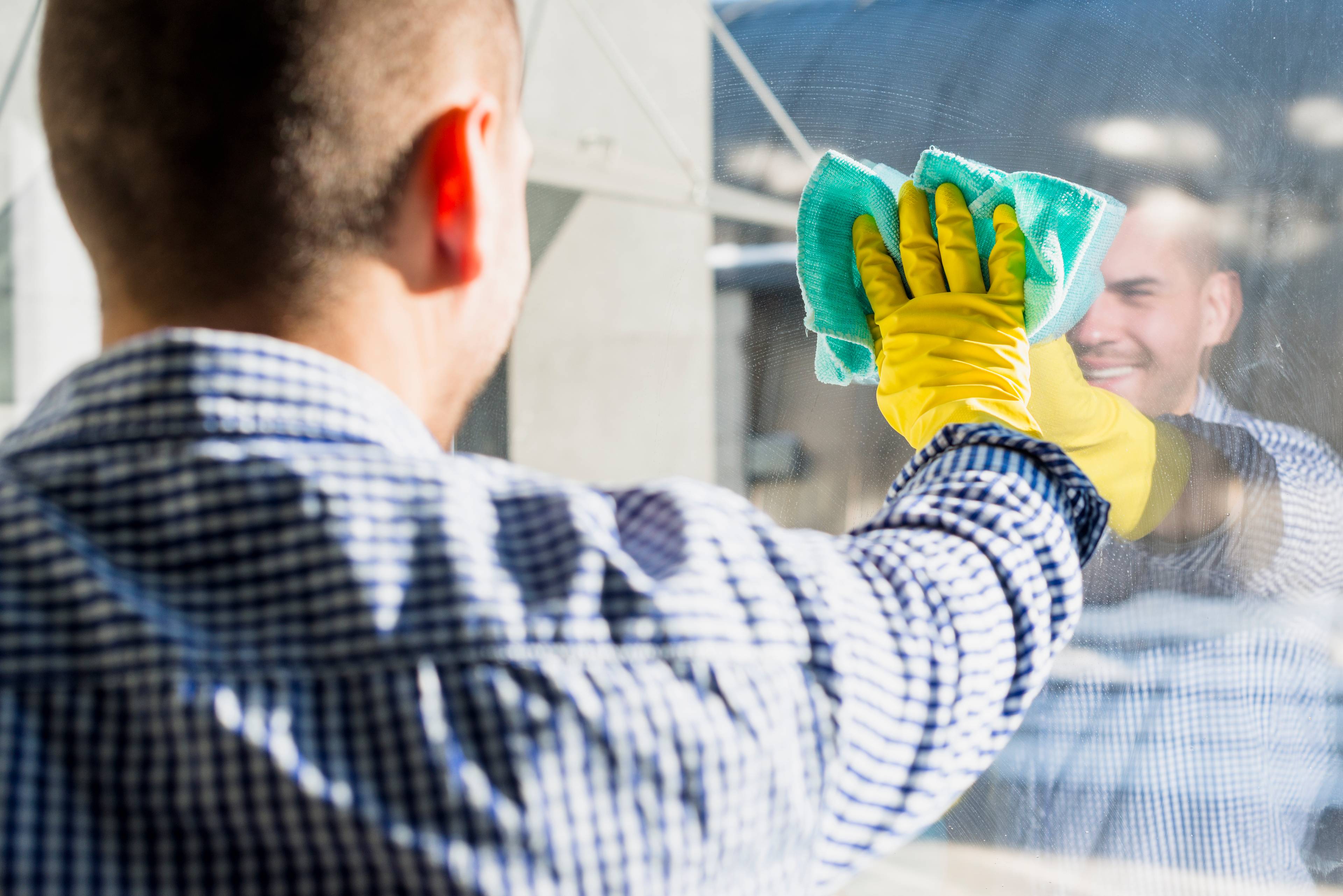 Man cleaning reflective glass