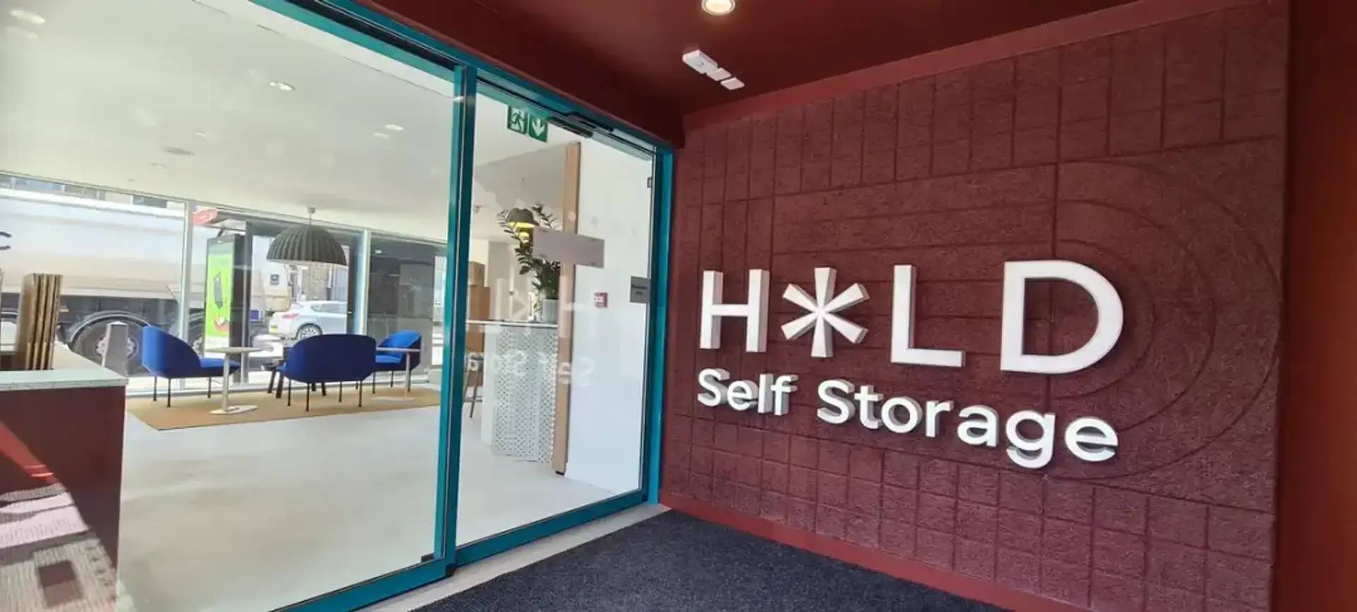 An office with the HOLD Self Storage logo on the wall