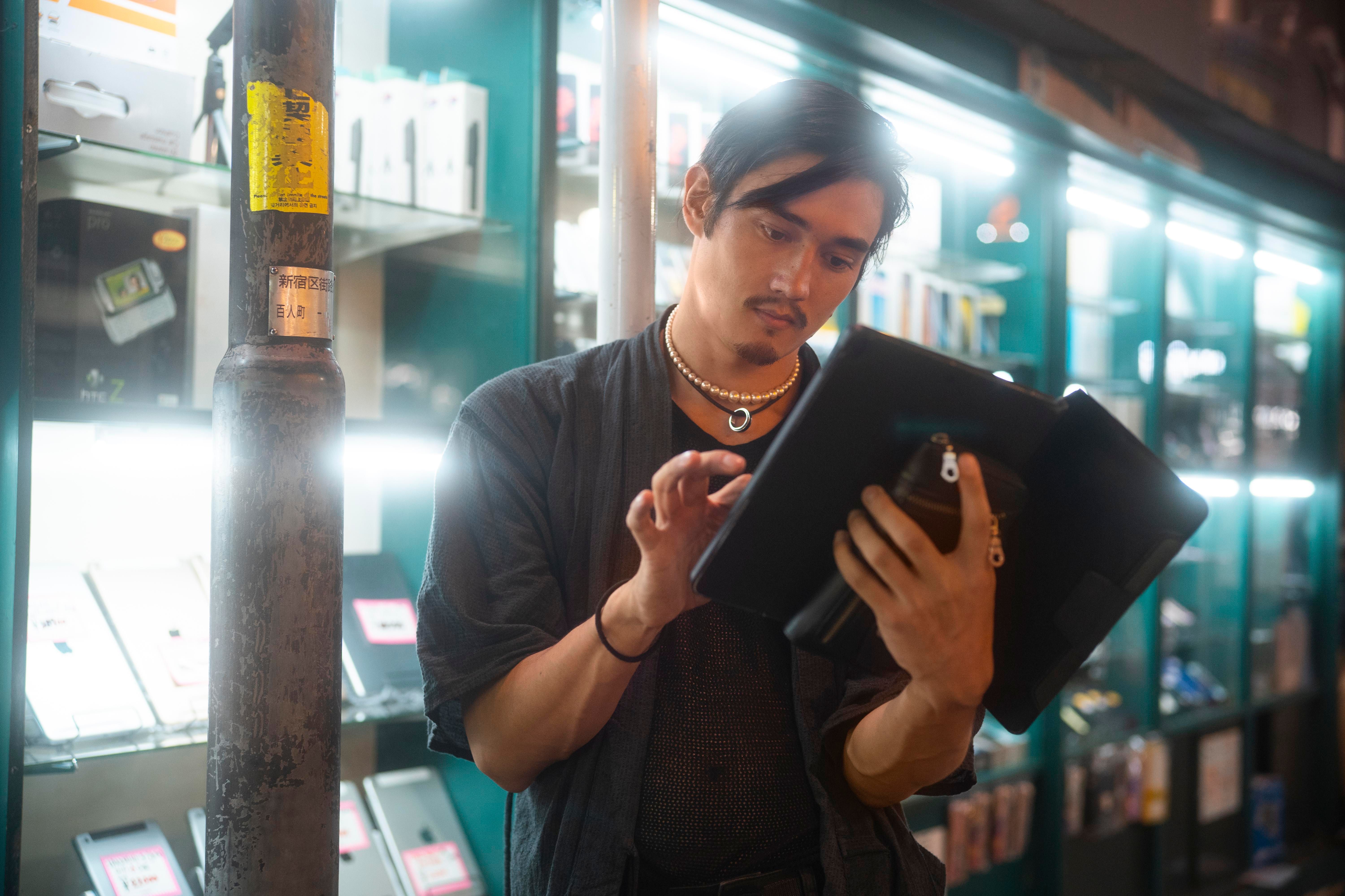 Young person checking inventory on tablet in shop