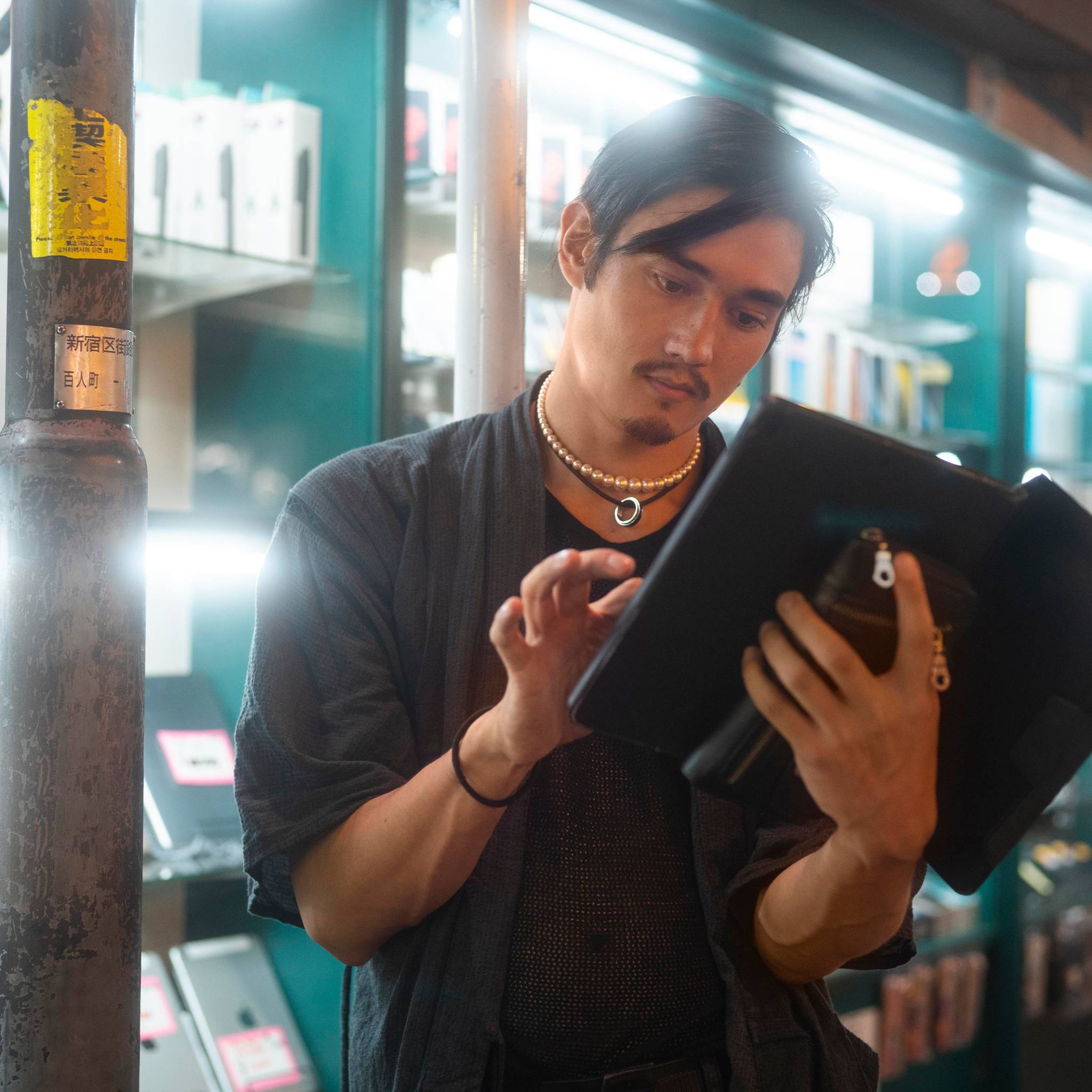 Young person checking inventory on tablet in shop